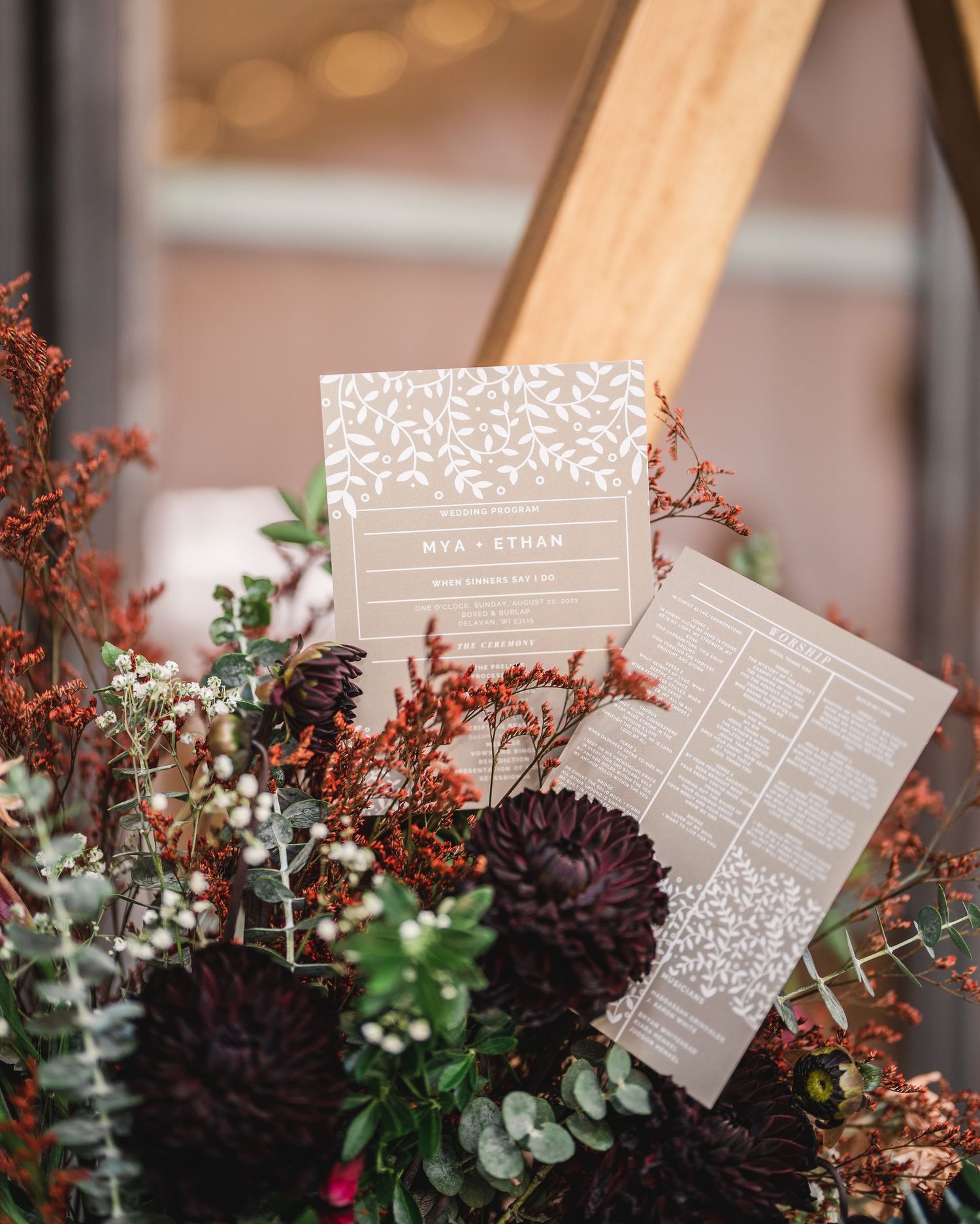 Wedding stationery and floral arrangements featuring deep purple blooms and greenery.