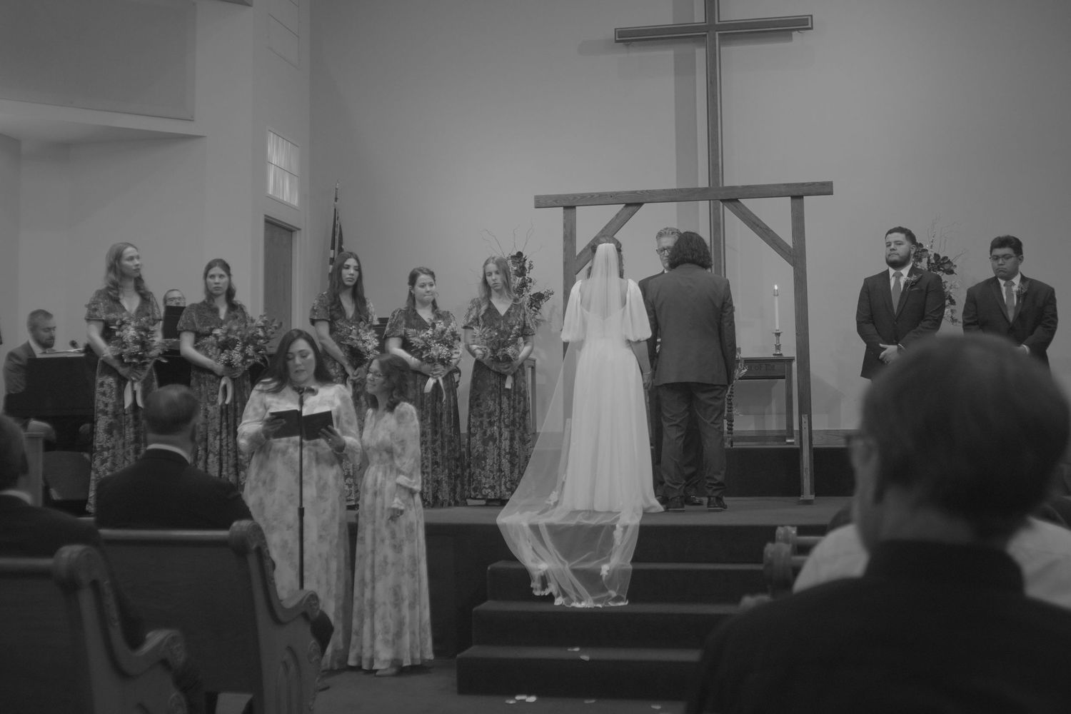 Black and white photo of wedding ceremony in traditional church setting.