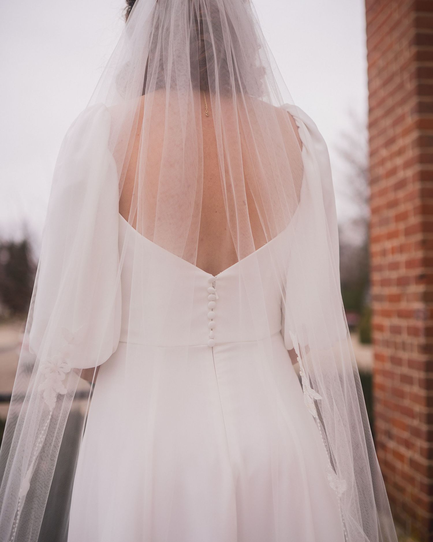 Close-up details of a flowing white wedding veil against a soft background.