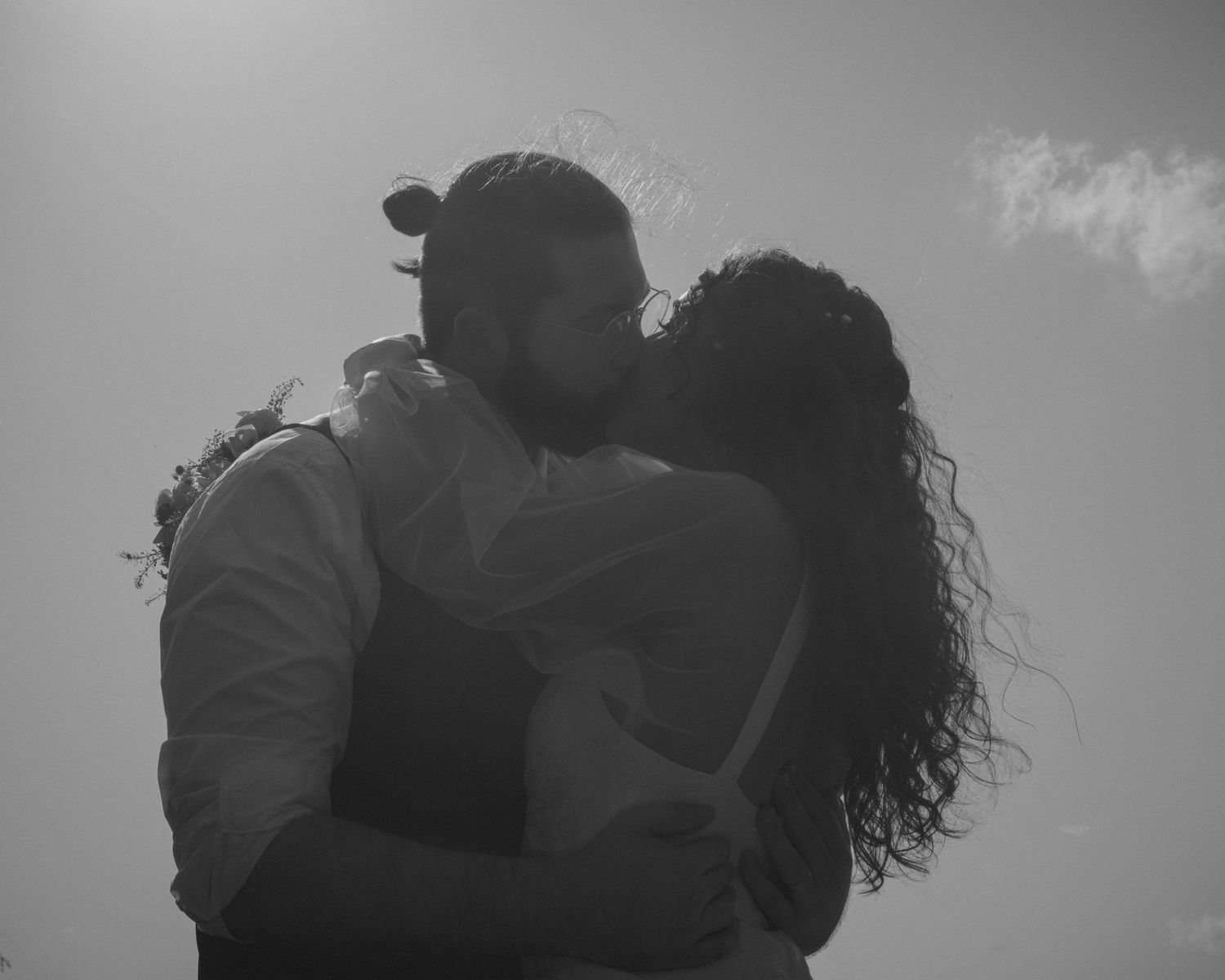 A romantic silhouette of a couple embracing in black and white photography.