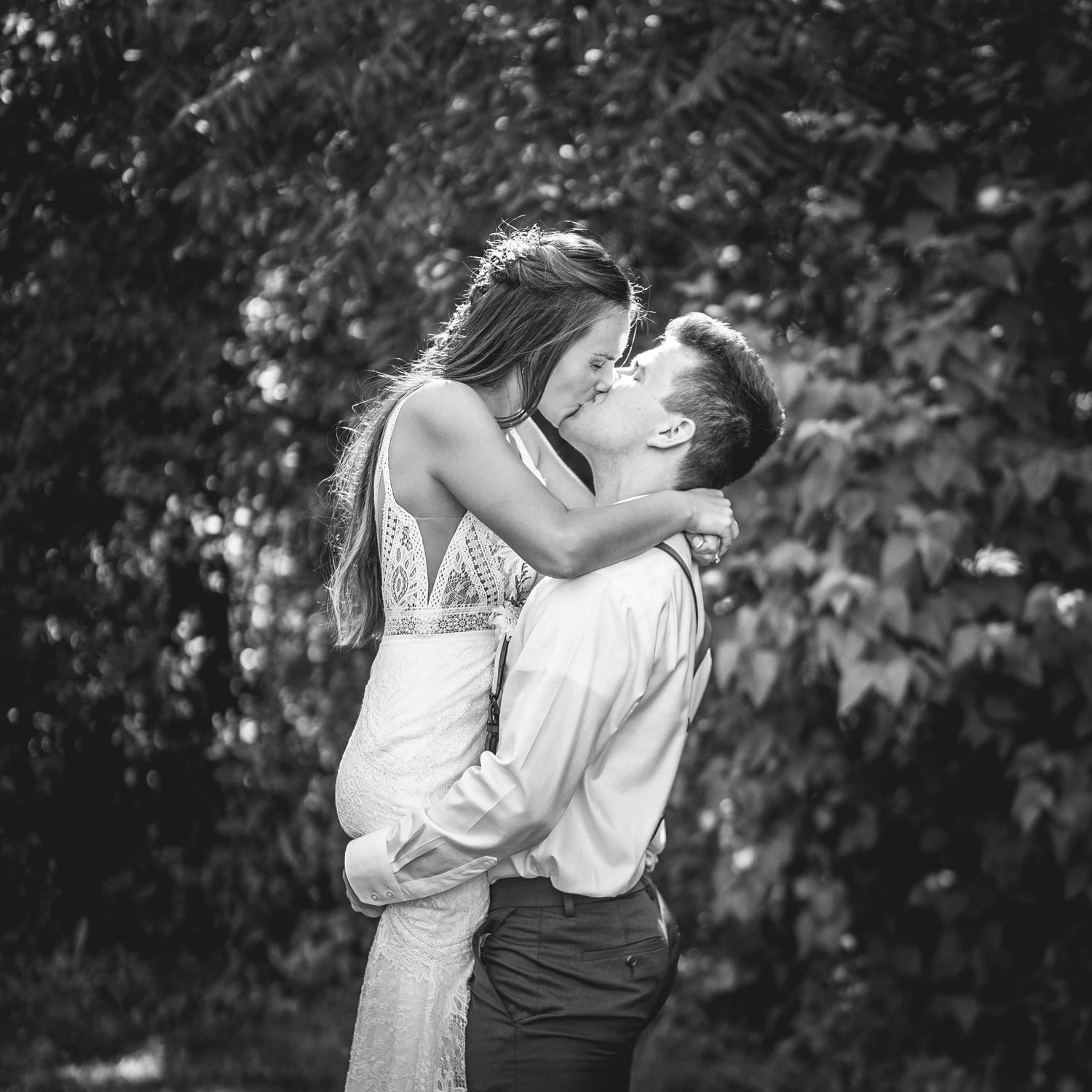 A romantic black and white photo sequence showing a couple sharing tender moments in an outdoor setting.