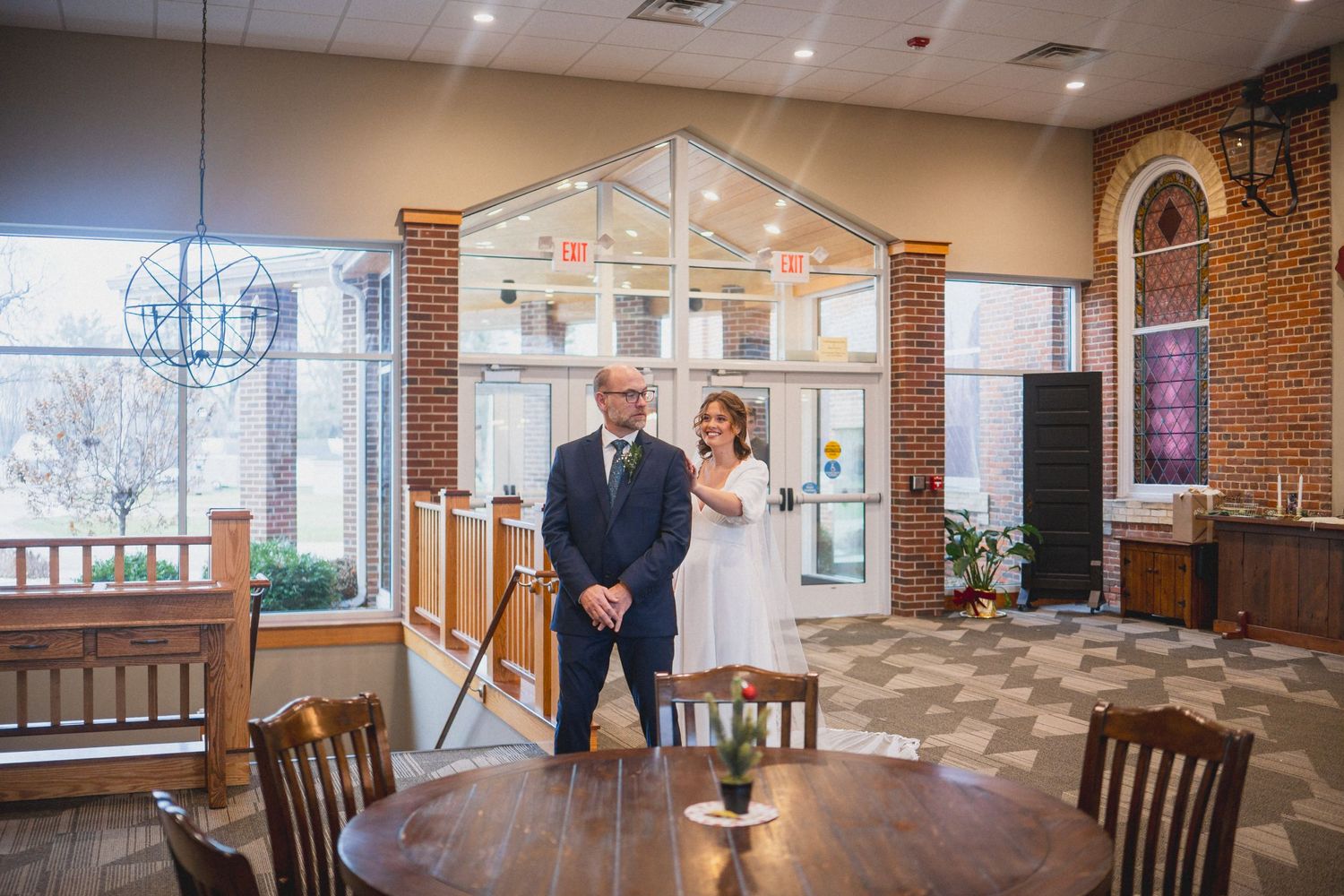 Church interior with wooden railings and world map decor during wedding ceremony.