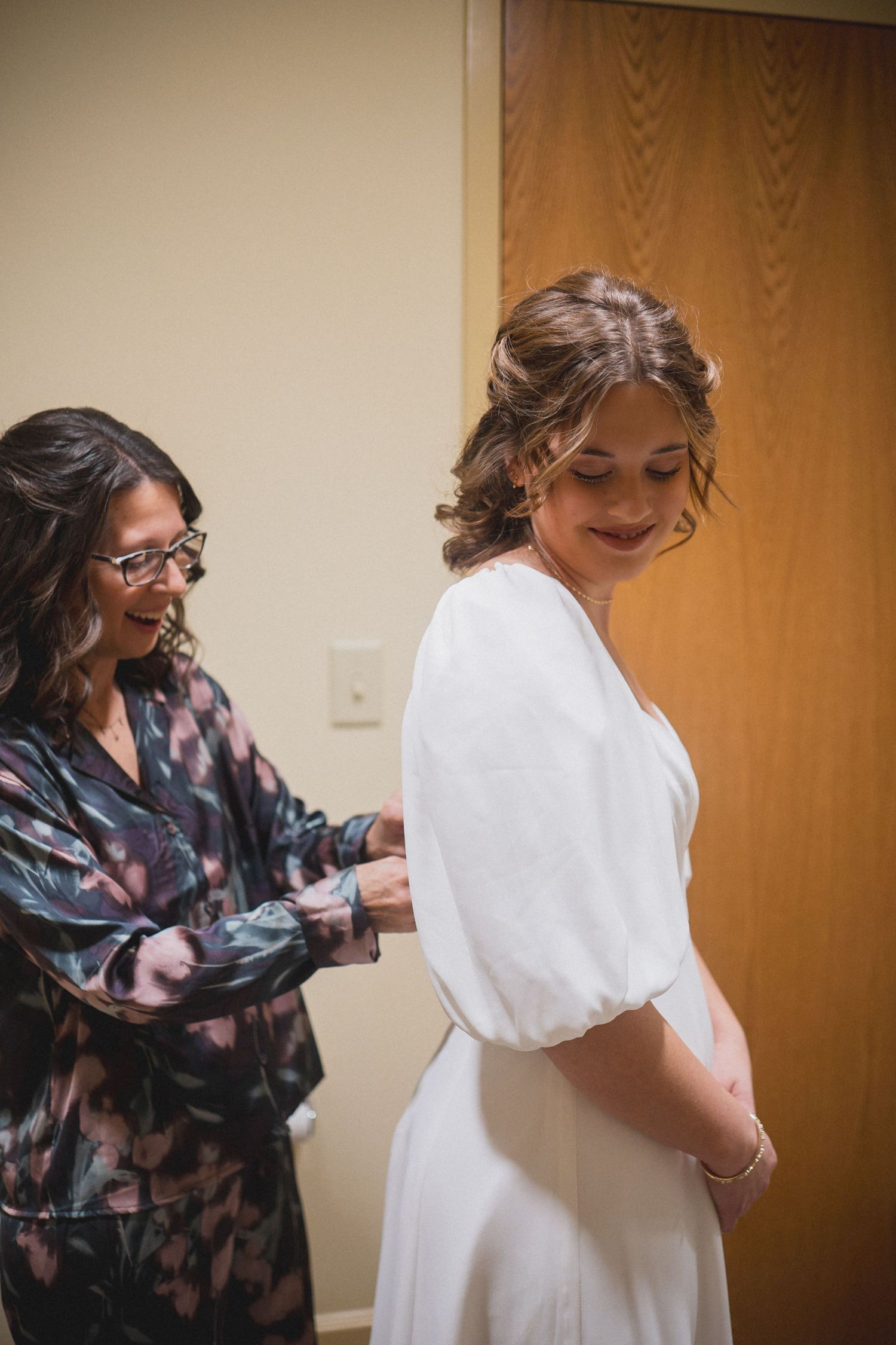 Getting ready scene with wedding dress preparation in a dressing room.