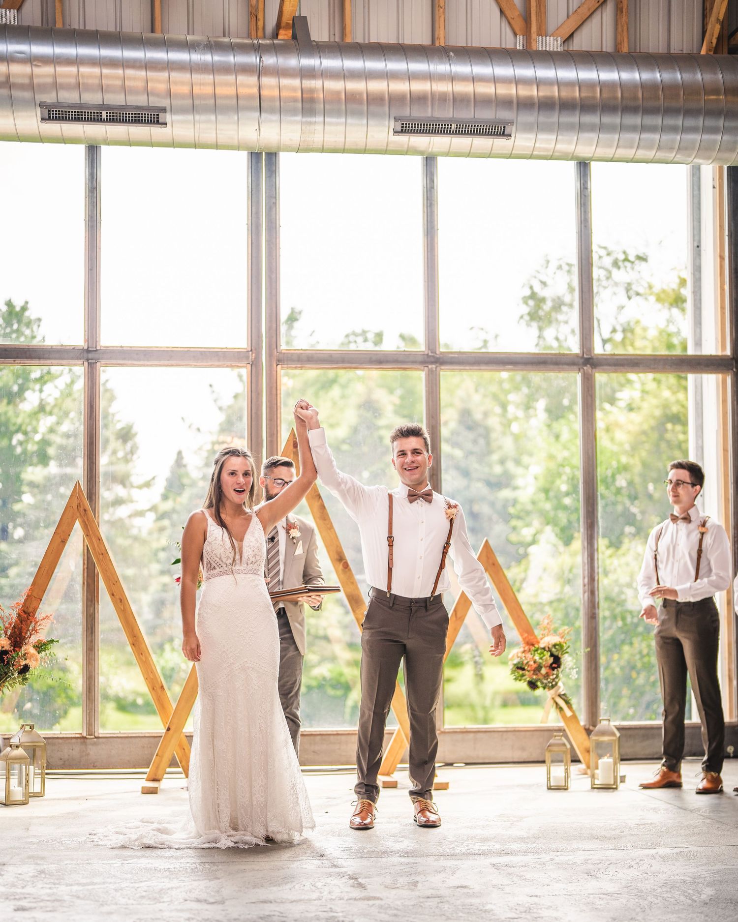 Wedding celebration in an airy indoor venue with natural light streaming through floor-to-ceiling windows.