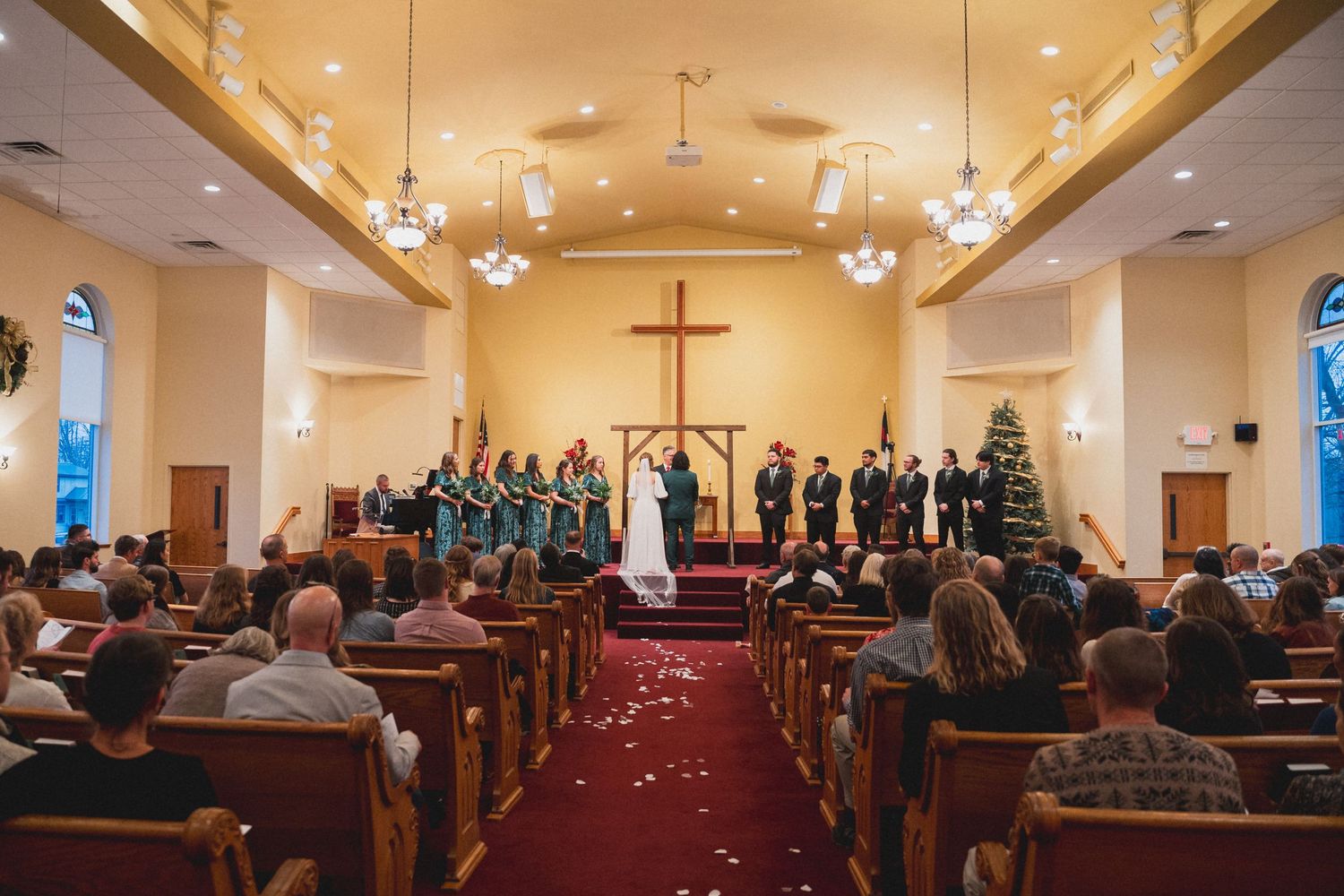 Wide angle view of church sanctuary filled with wedding guests.
