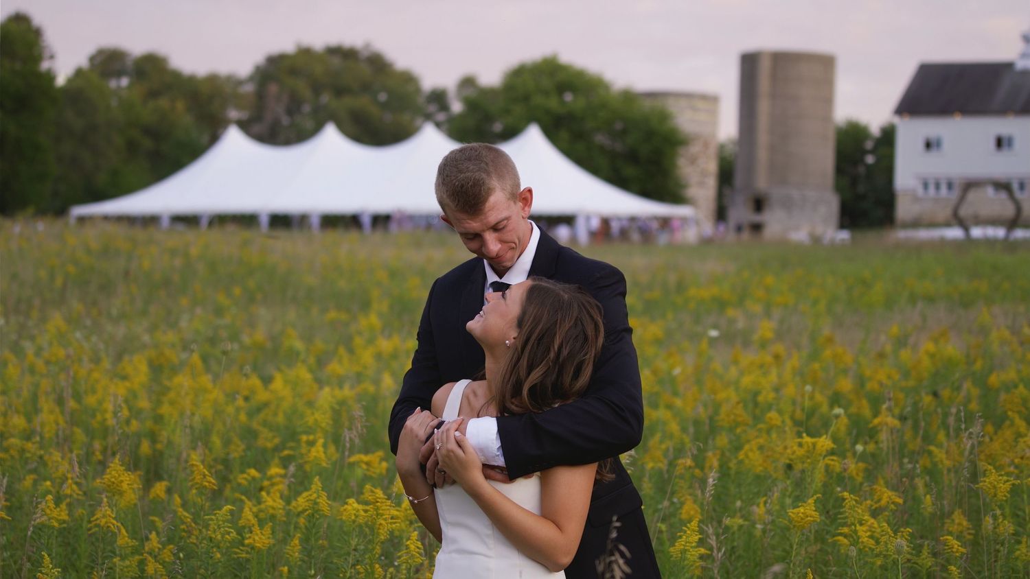 Romantic wedding portraits in a field of yellow wildflowers during golden hour.