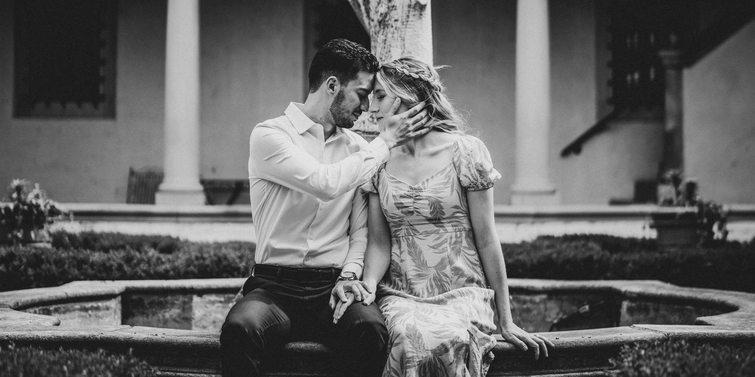 Romantic engagement photos in an elegant Spanish colonial courtyard setting.