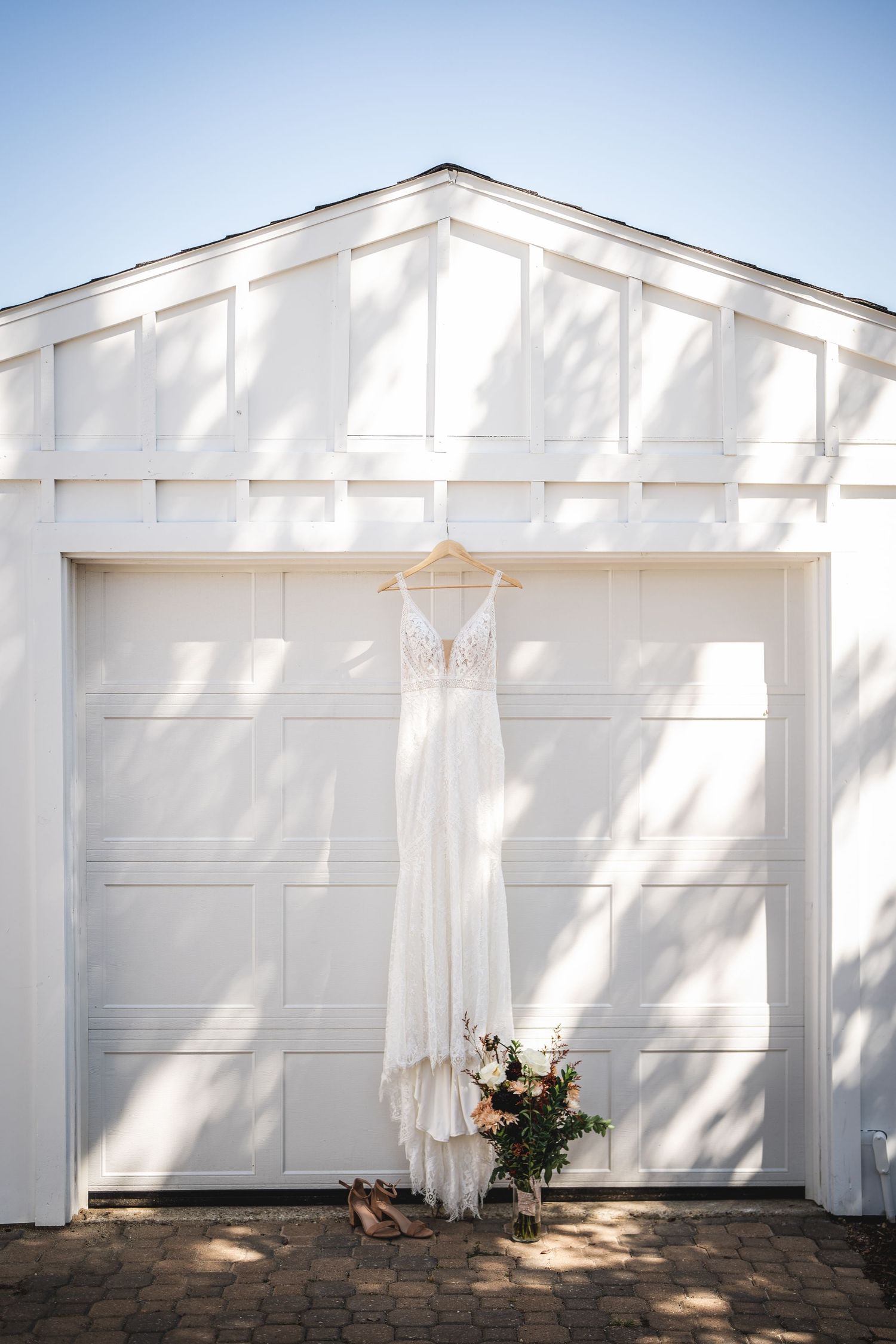 White garage doors with sheer curtains creating a bright, airy wedding ceremony backdrop.