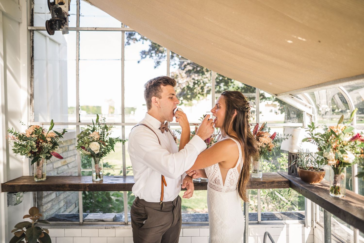Wedding celebration in an airy indoor-outdoor venue with draped fabric and natural lighting.