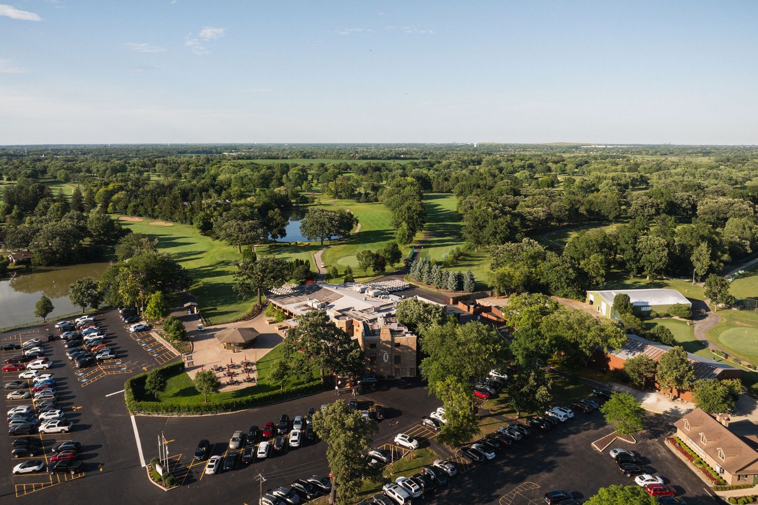 Aerial view of elegant country club wedding venue surrounded by golf course.