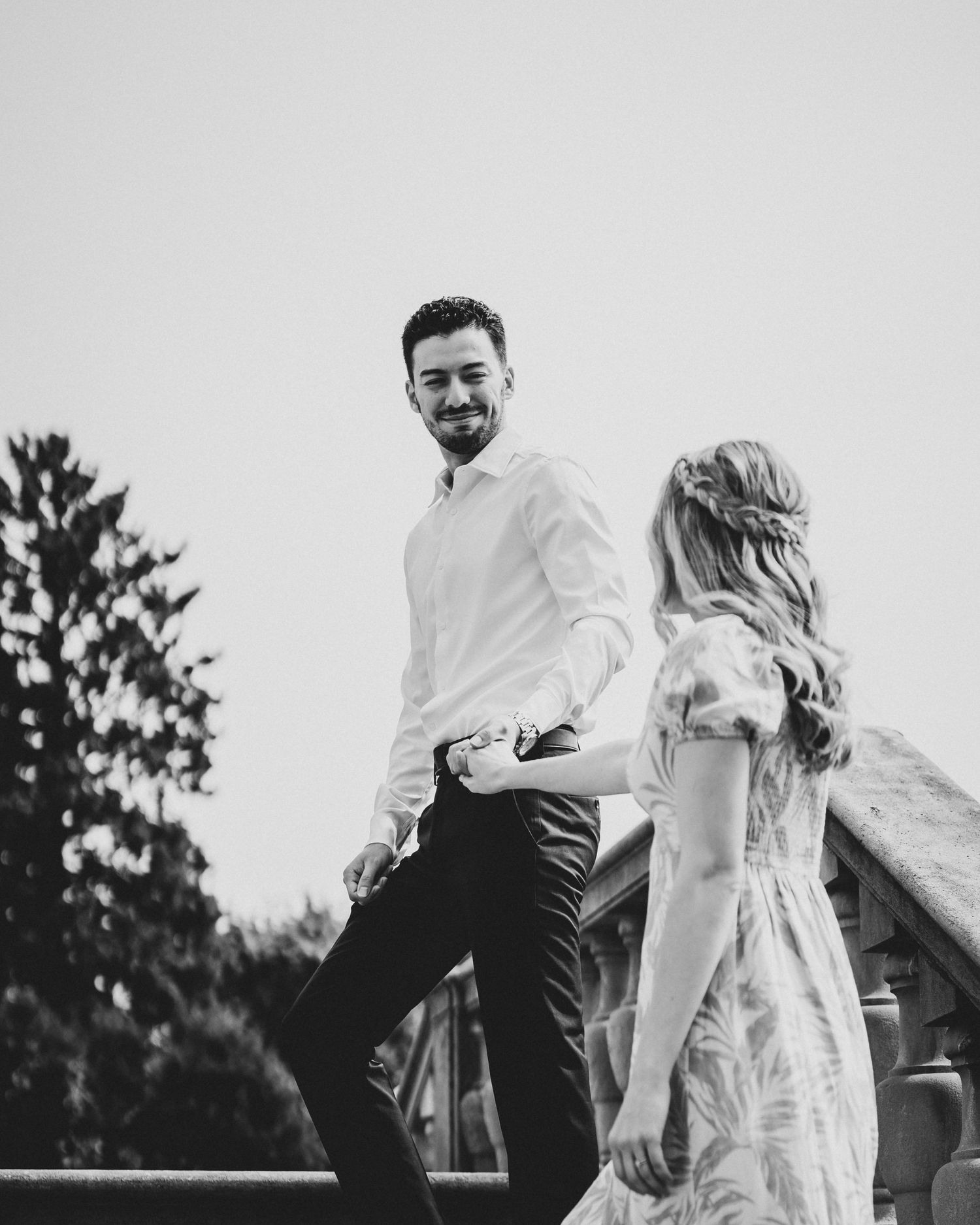 A black and white photo of a couple dancing outdoors in an intimate moment.