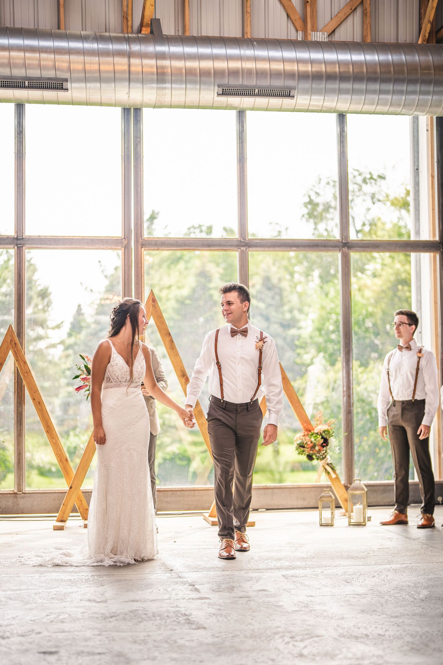 Candid moments captured during a wedding celebration in a modern venue with large windows.