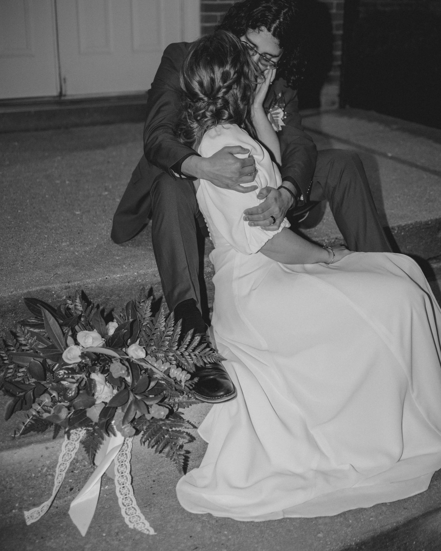Wedding couple shares intimate kisses with floral decorations visible in foreground.