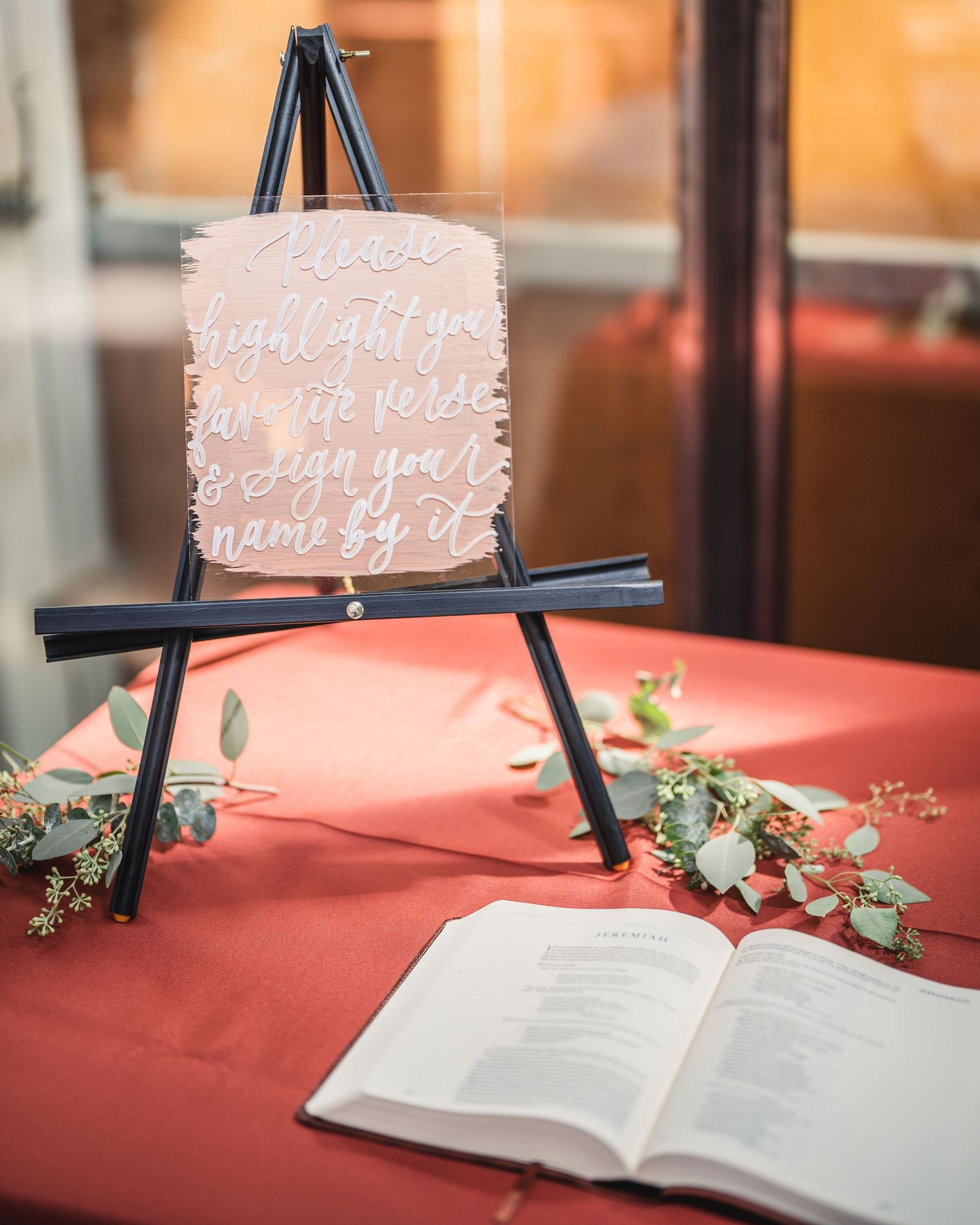 Wedding guestbook display with decorative signs on easels and floral accents.