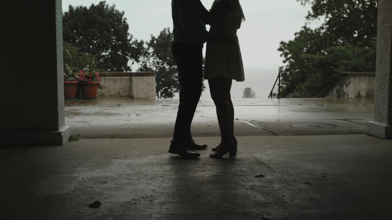 Engagement film of an engaged couple dance slowly and lean in for a tender kiss.