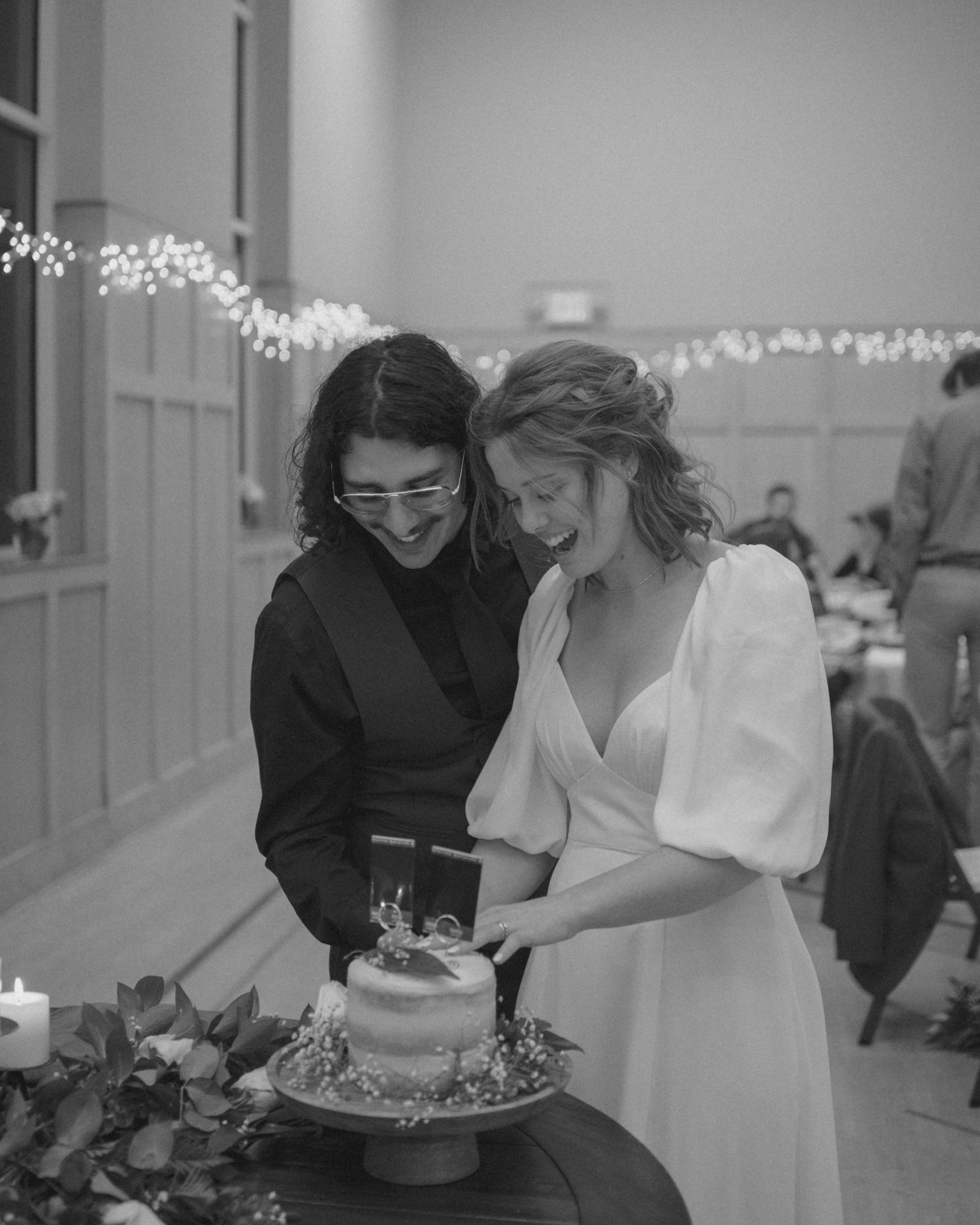 A couple shares an intimate moment while cutting their wedding cake.