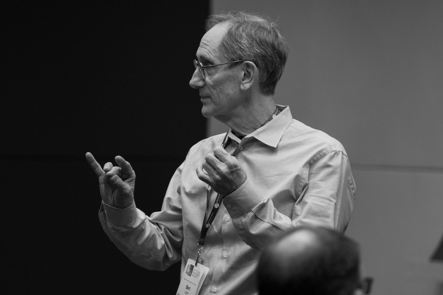 Presenter making animated hand gestures during a lecture.