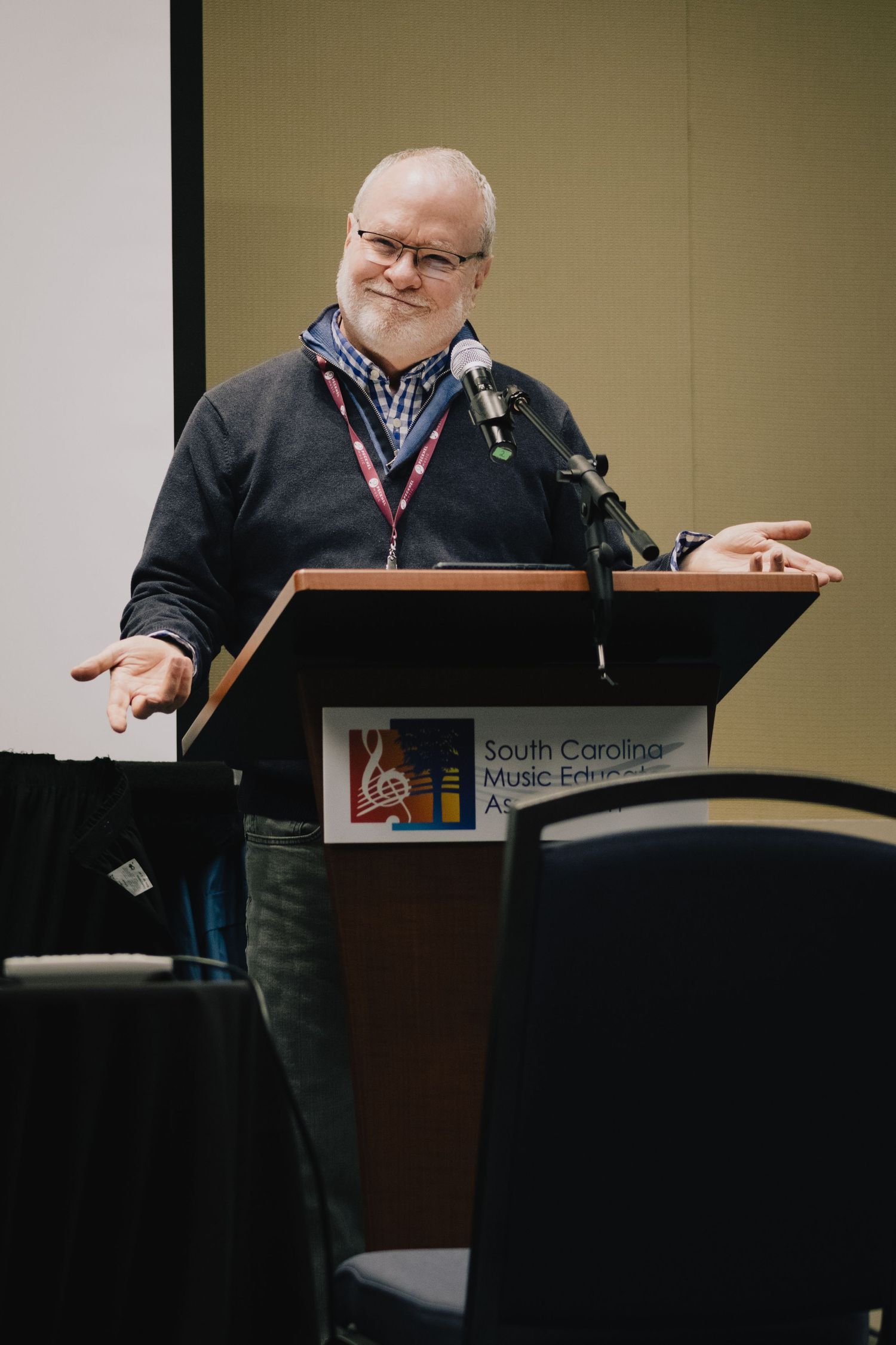 Speaker standing at podium during professional conference presentation.