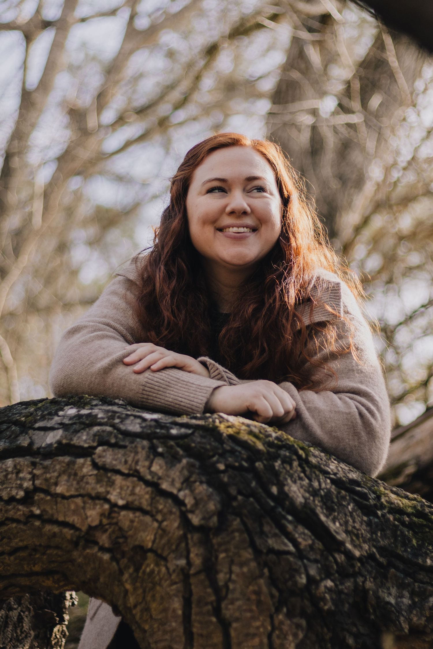 Natural outdoor portrait of someone resting on a tree trunk.