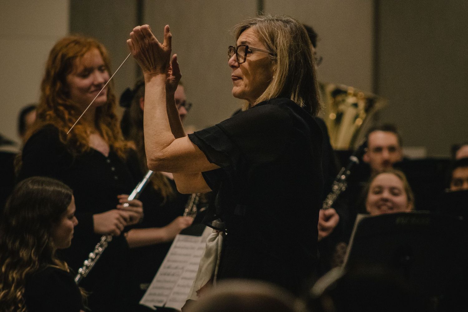 Orchestra conductor directing musicians during a performance.