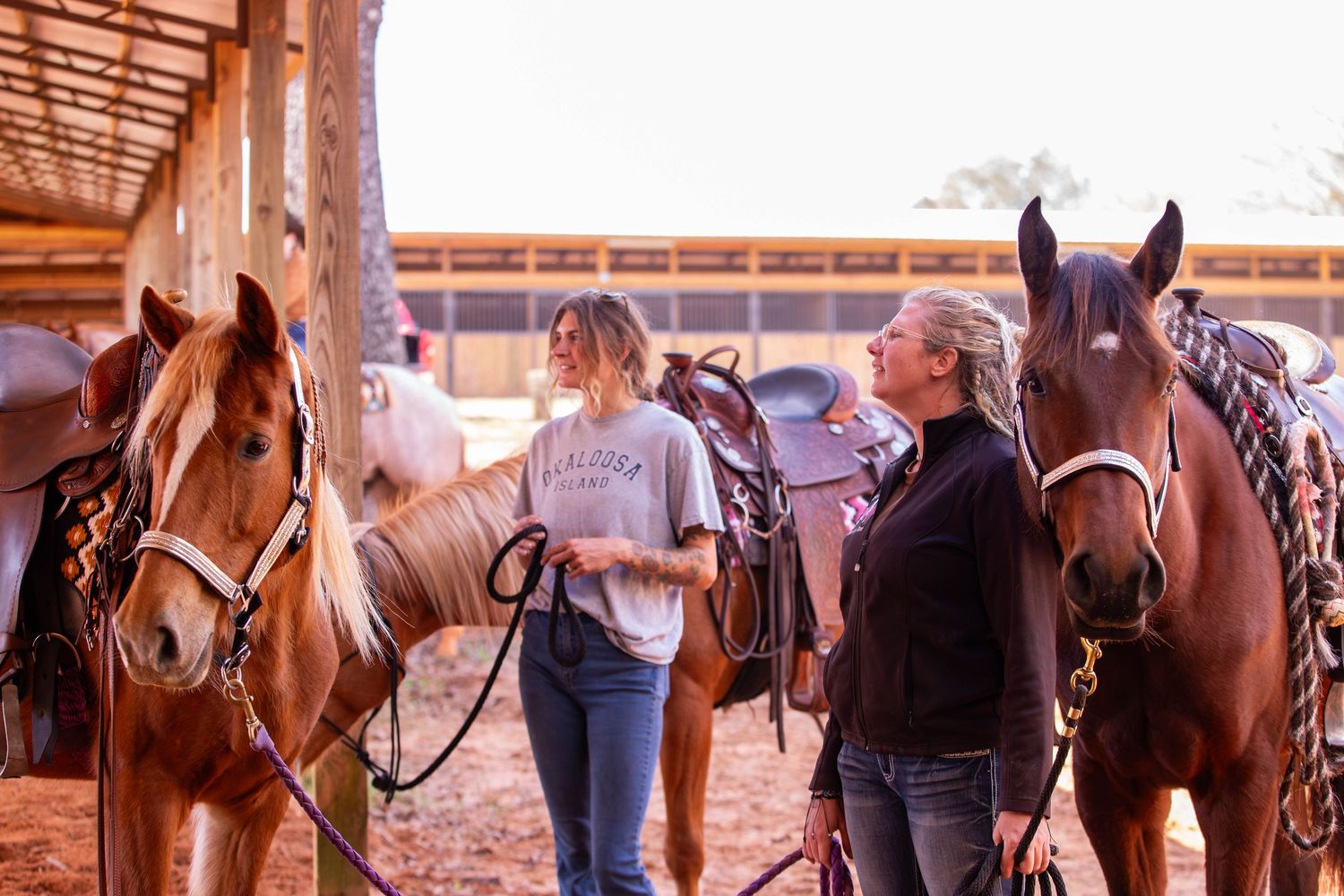 Candid photo of barn members holding horses at a horse show.