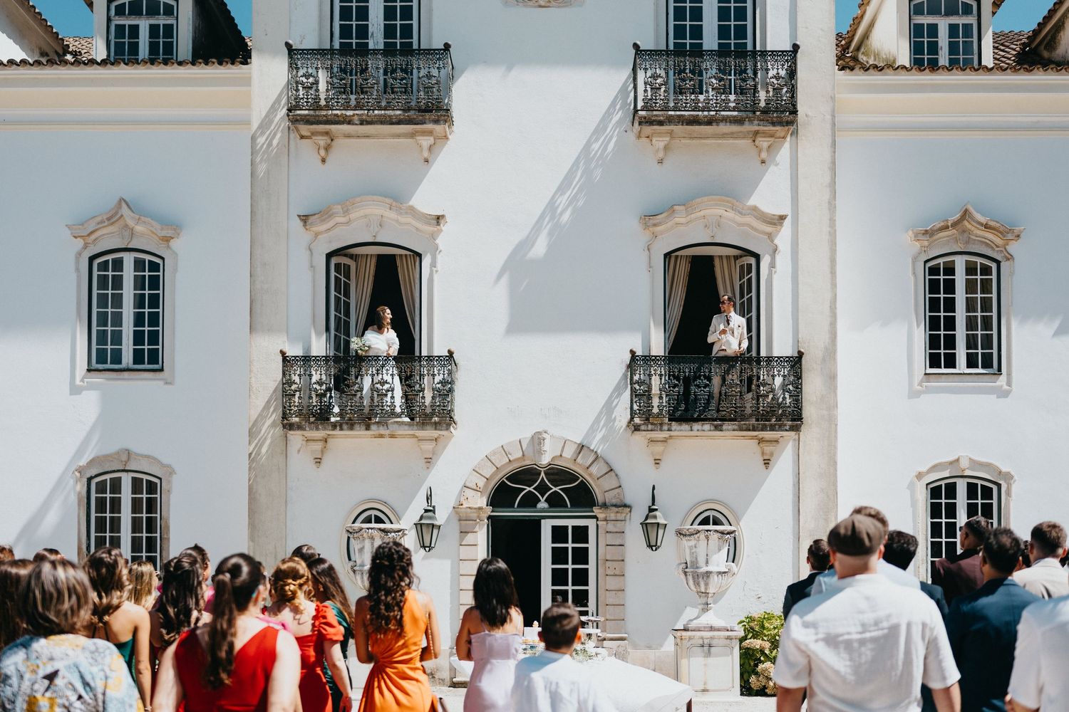 Classic white palace facade with ornate windows serves as elegant wedding venue backdrop.