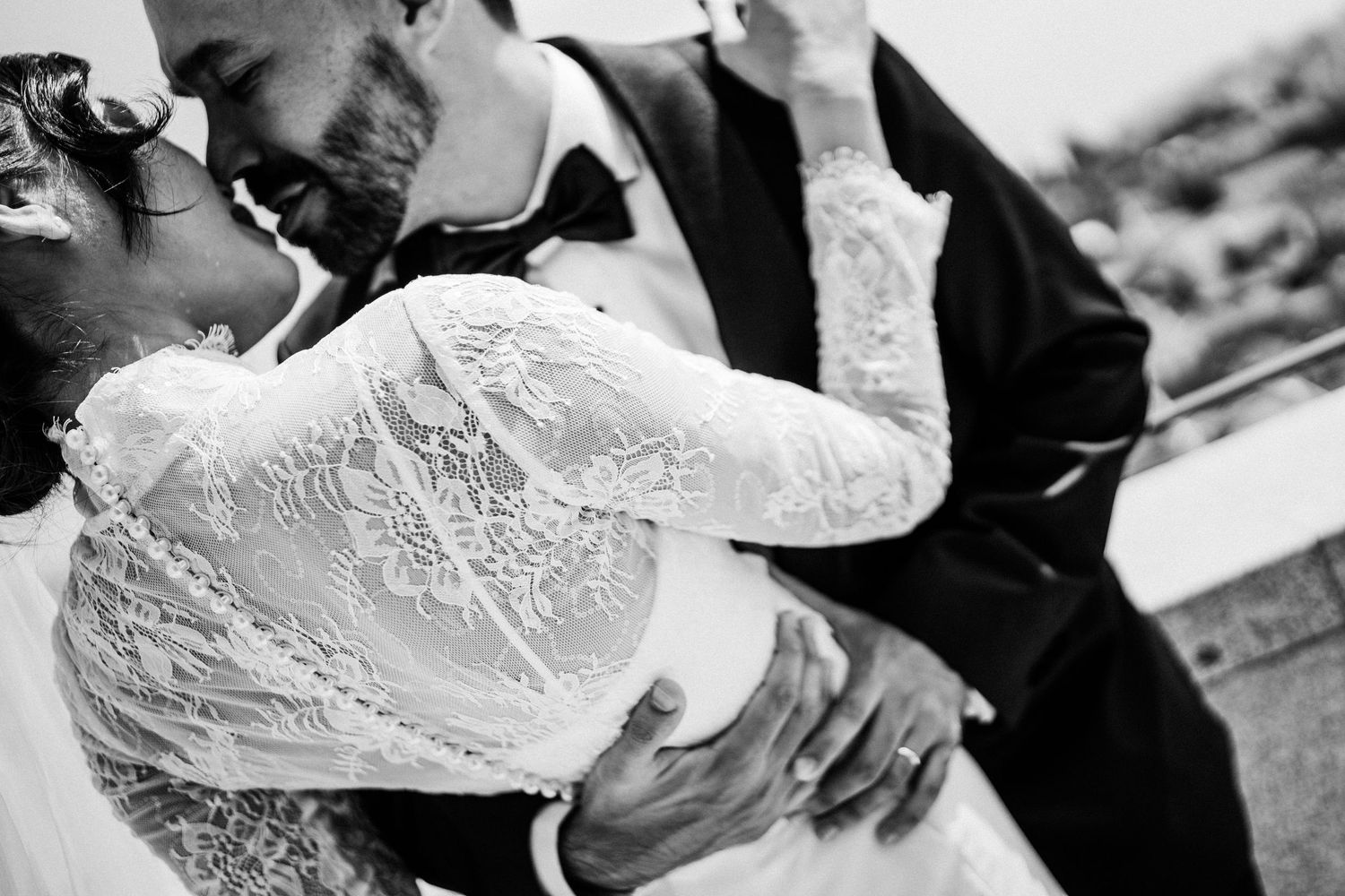 A black and white close-up of an intimate moment between newlyweds.