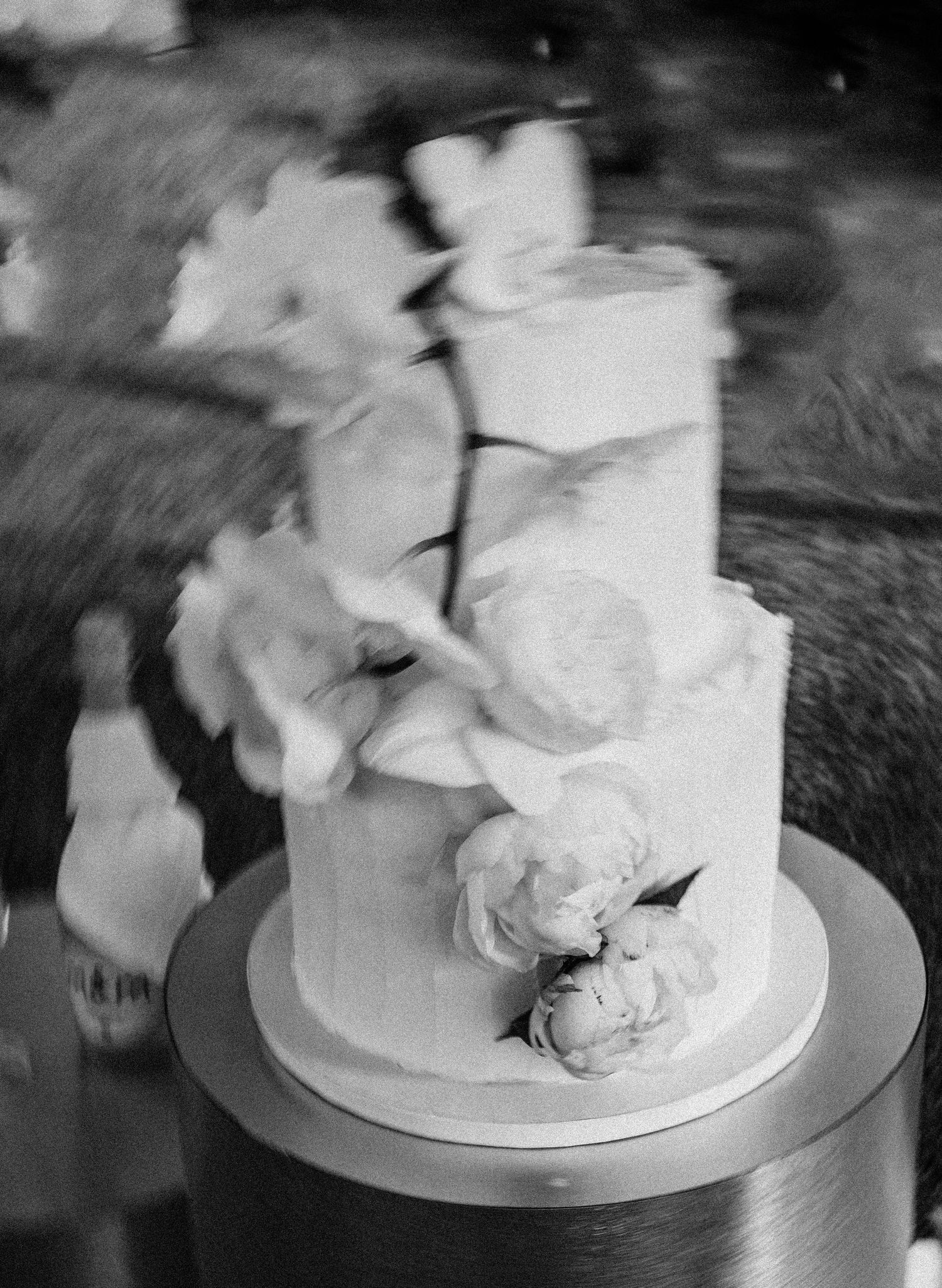 An elegant white wedding cake decorated with soft floral details.