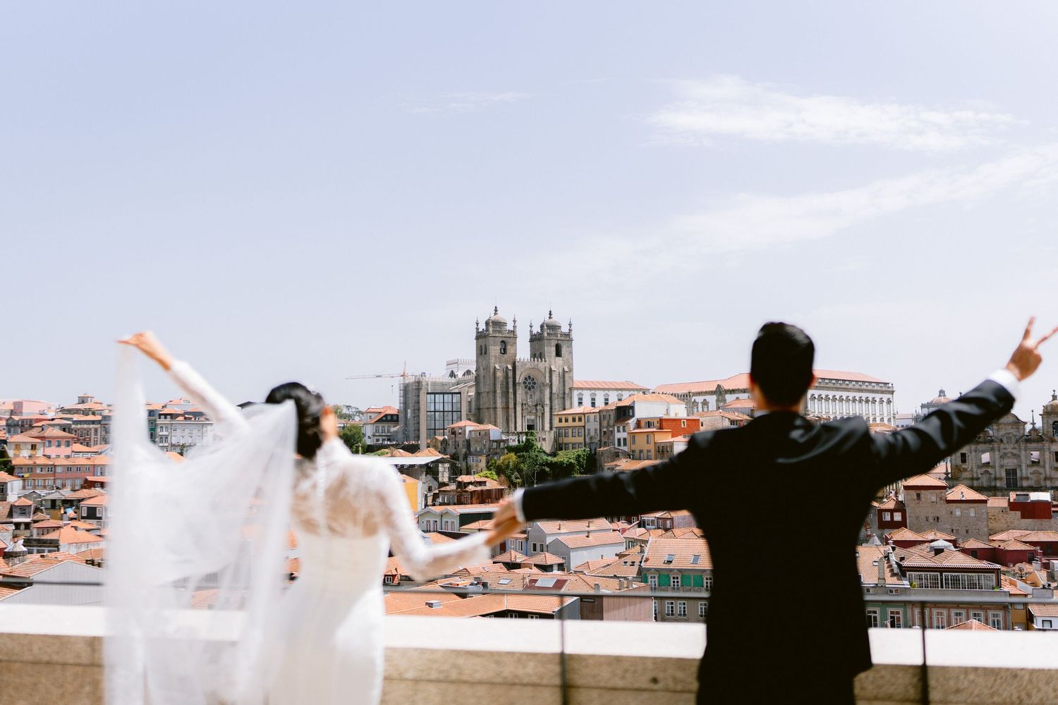 Silhouettes celebrating on a rooftop with city skyline in background.