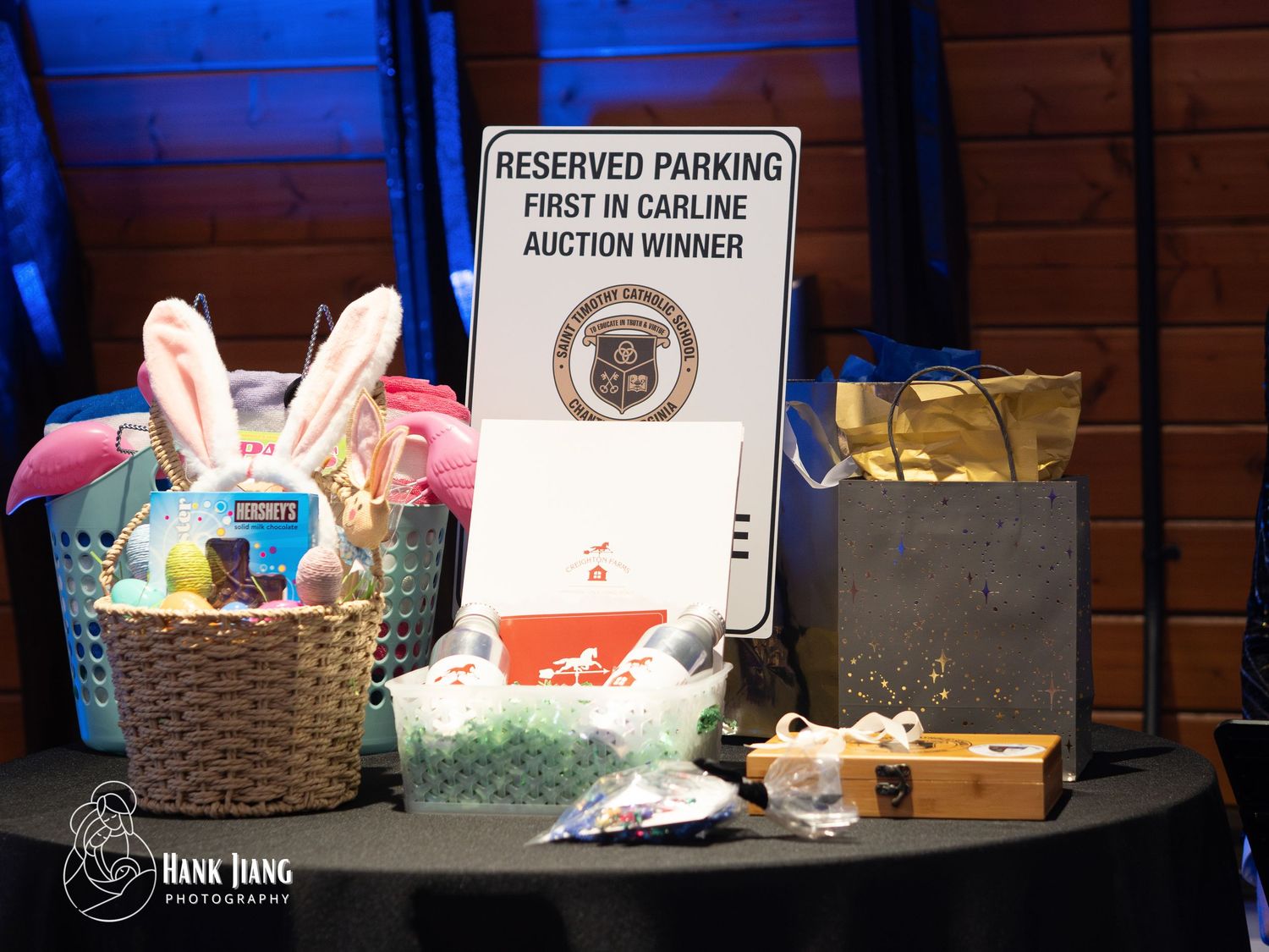 Auction prize table with Easter basket, gift bags, and Reserved Parking First in Carline sign at a school fundraiser event.