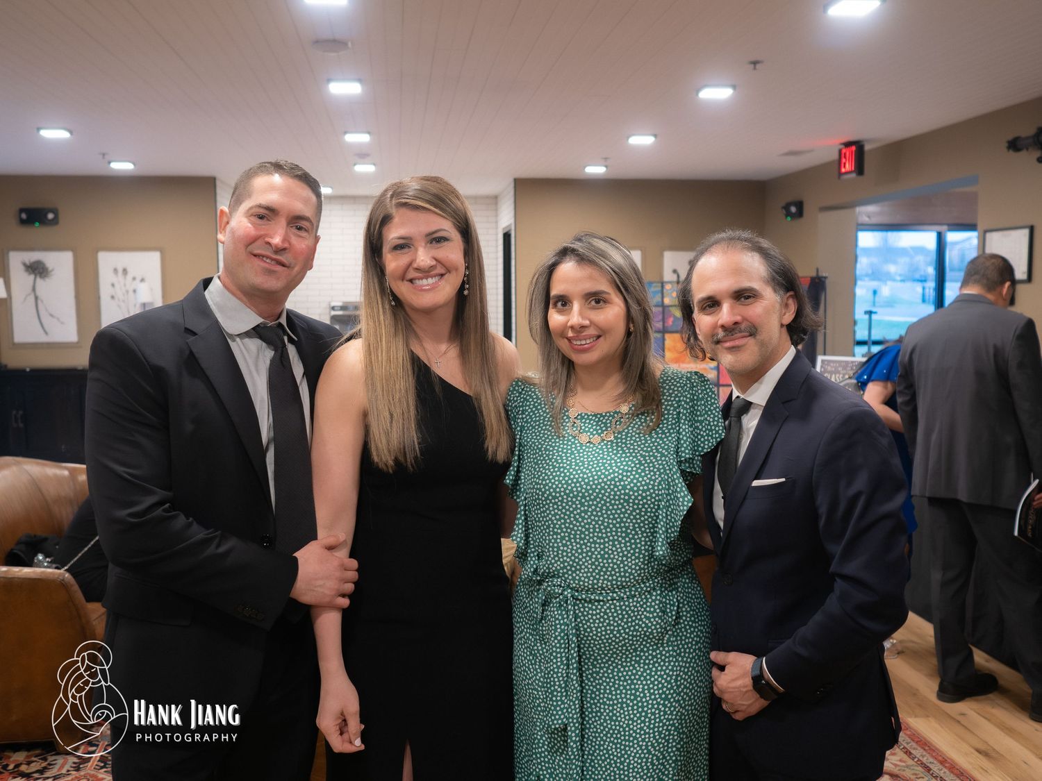 Four elegantly dressed professionals posing together at a formal event, captured by Hank Jiang Photography.