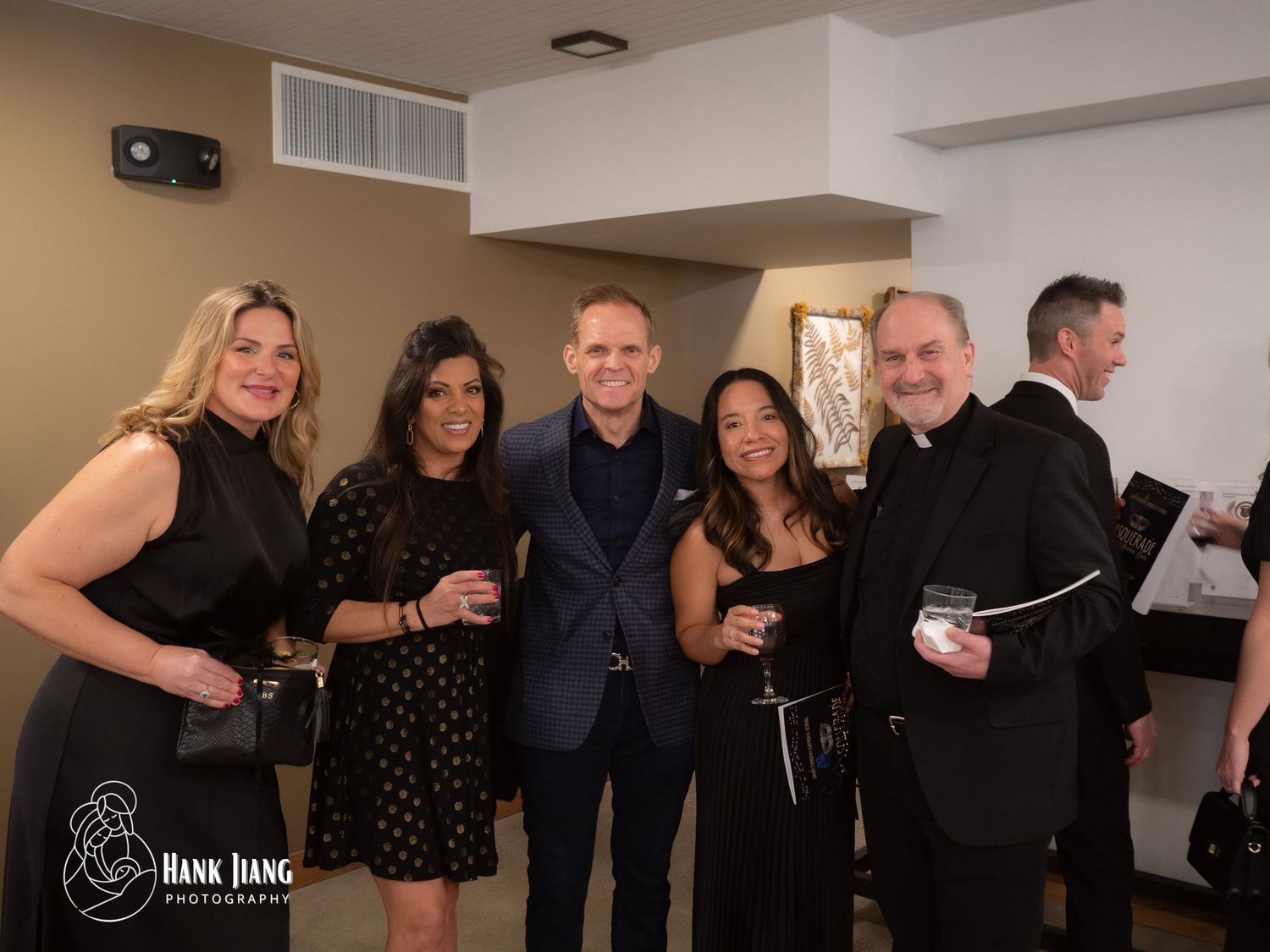 Five elegantly dressed guests smile together at a formal evening event, photographed by Hank Jiang Photography.