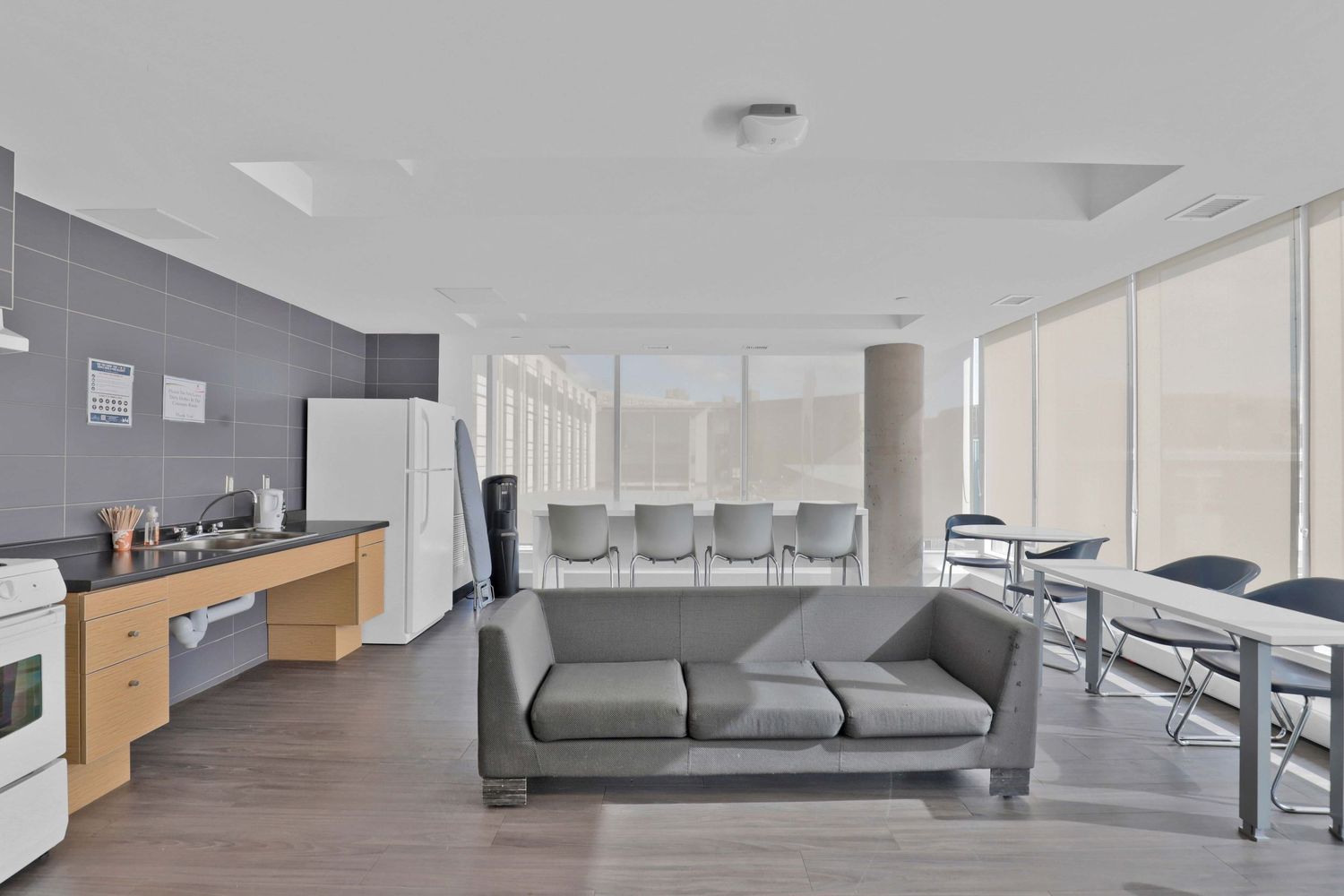 Modern minimalist office space with gray furniture and white walls.