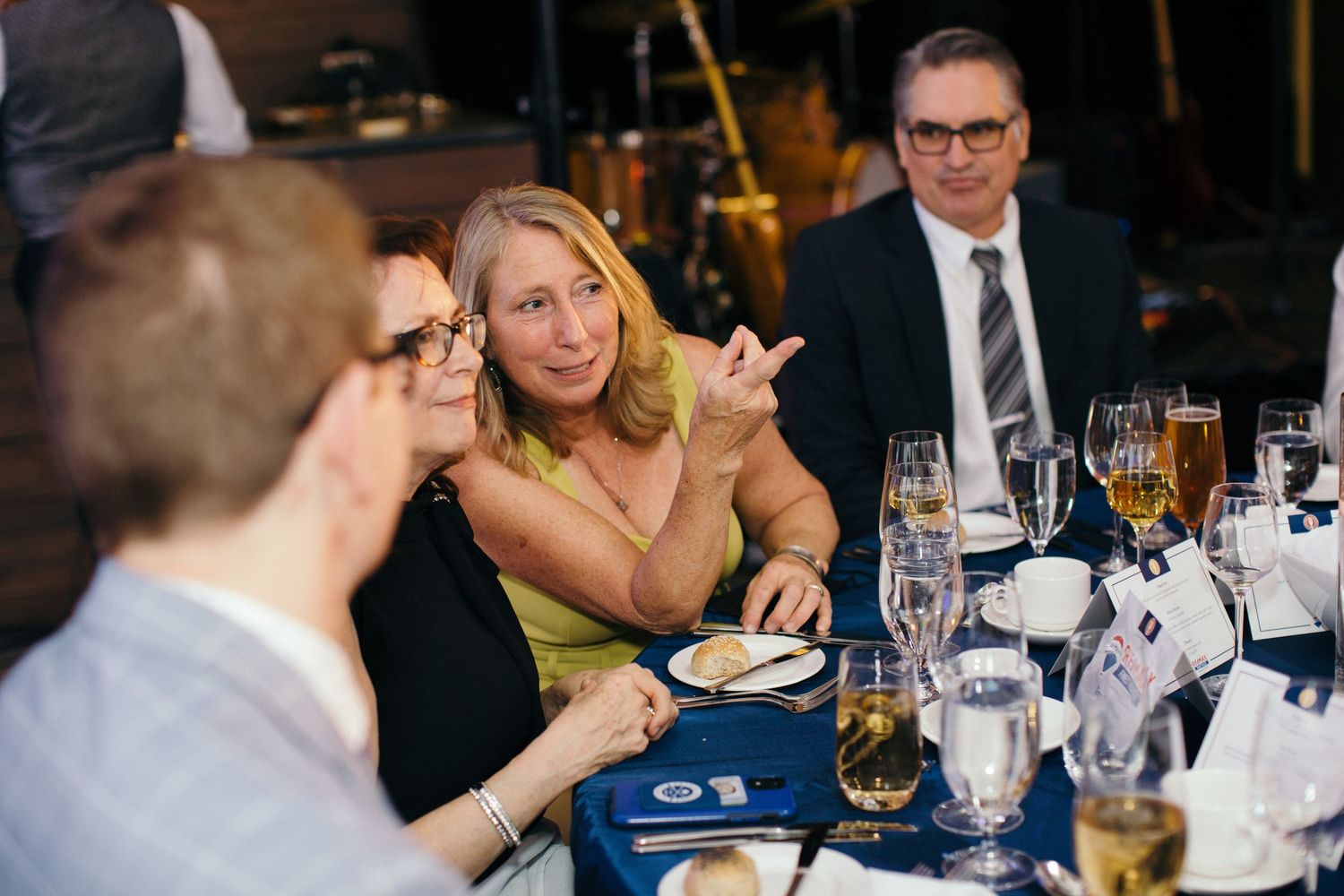 Elegant dinner setting with guests enjoying conversation at formal tables.