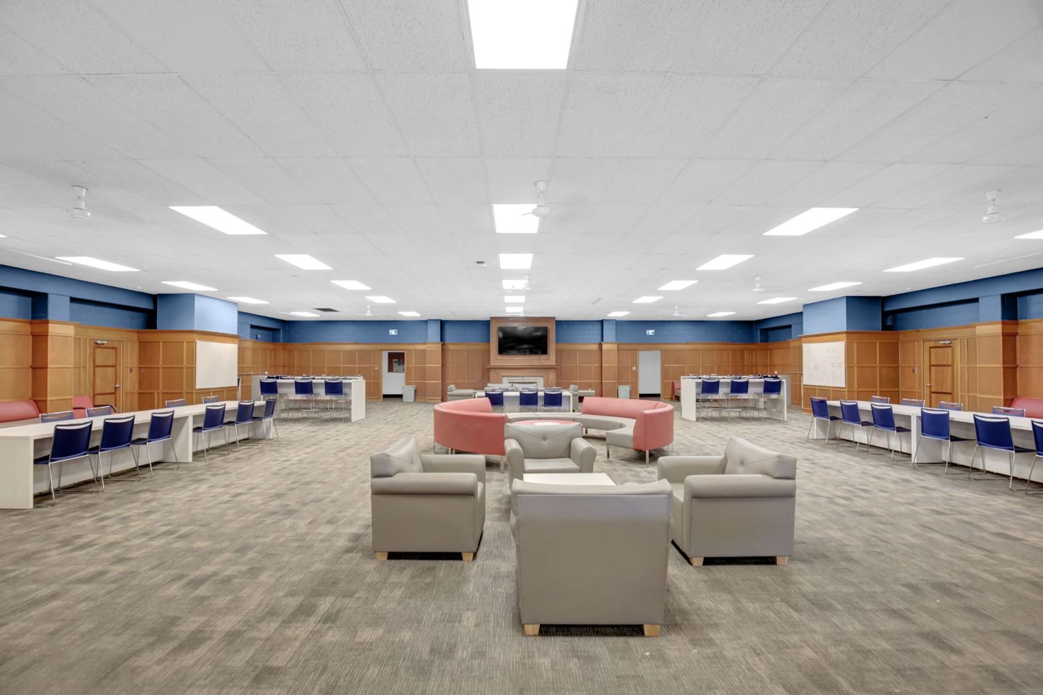 Large empty conference room with carpeted floor and fluorescent lighting.