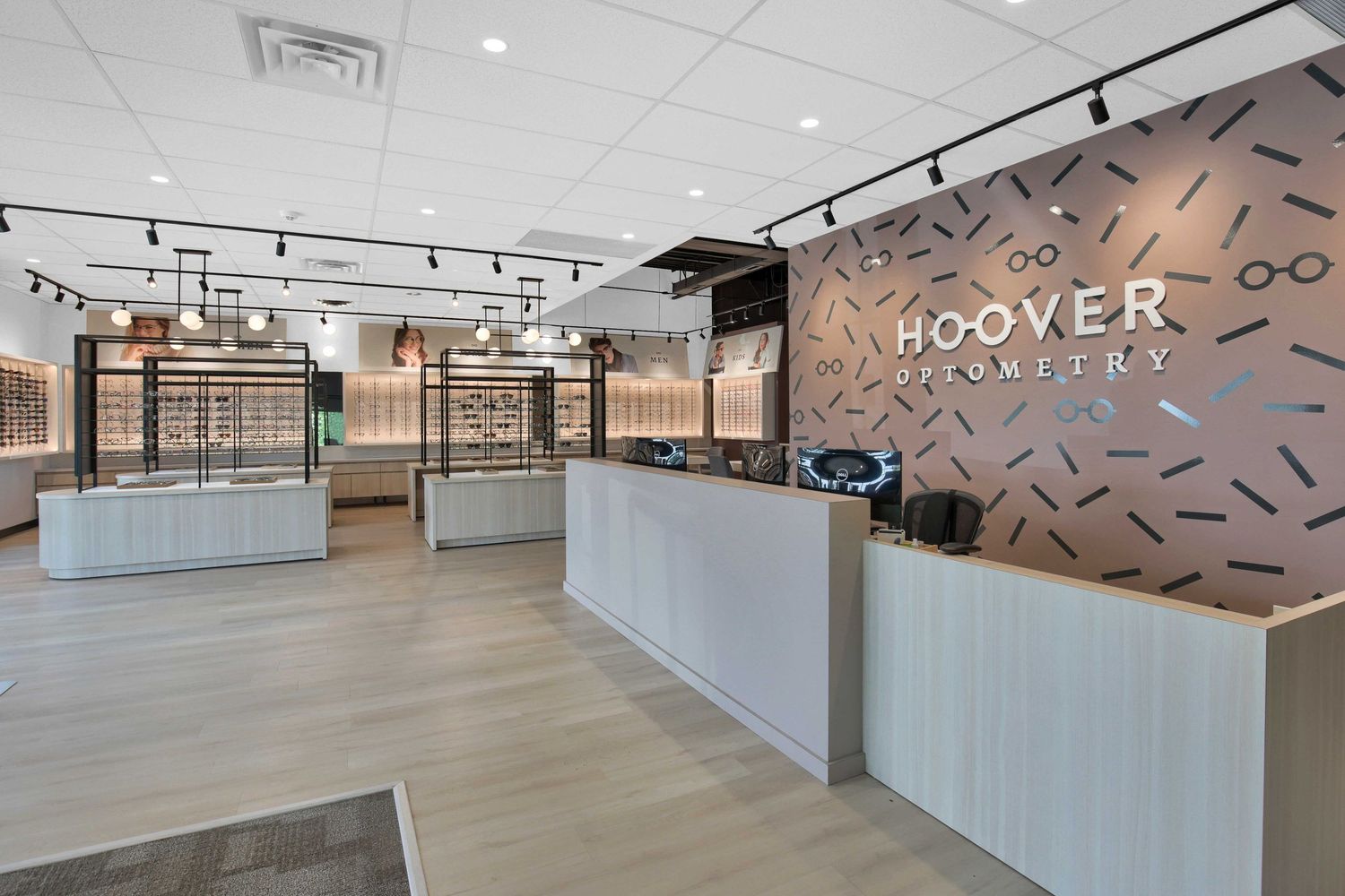 Modern reception area with white counters and geometric wall design featuring the Hoover brand name.