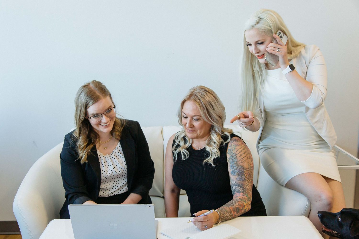 Team meeting in bright modern office space with white furniture.