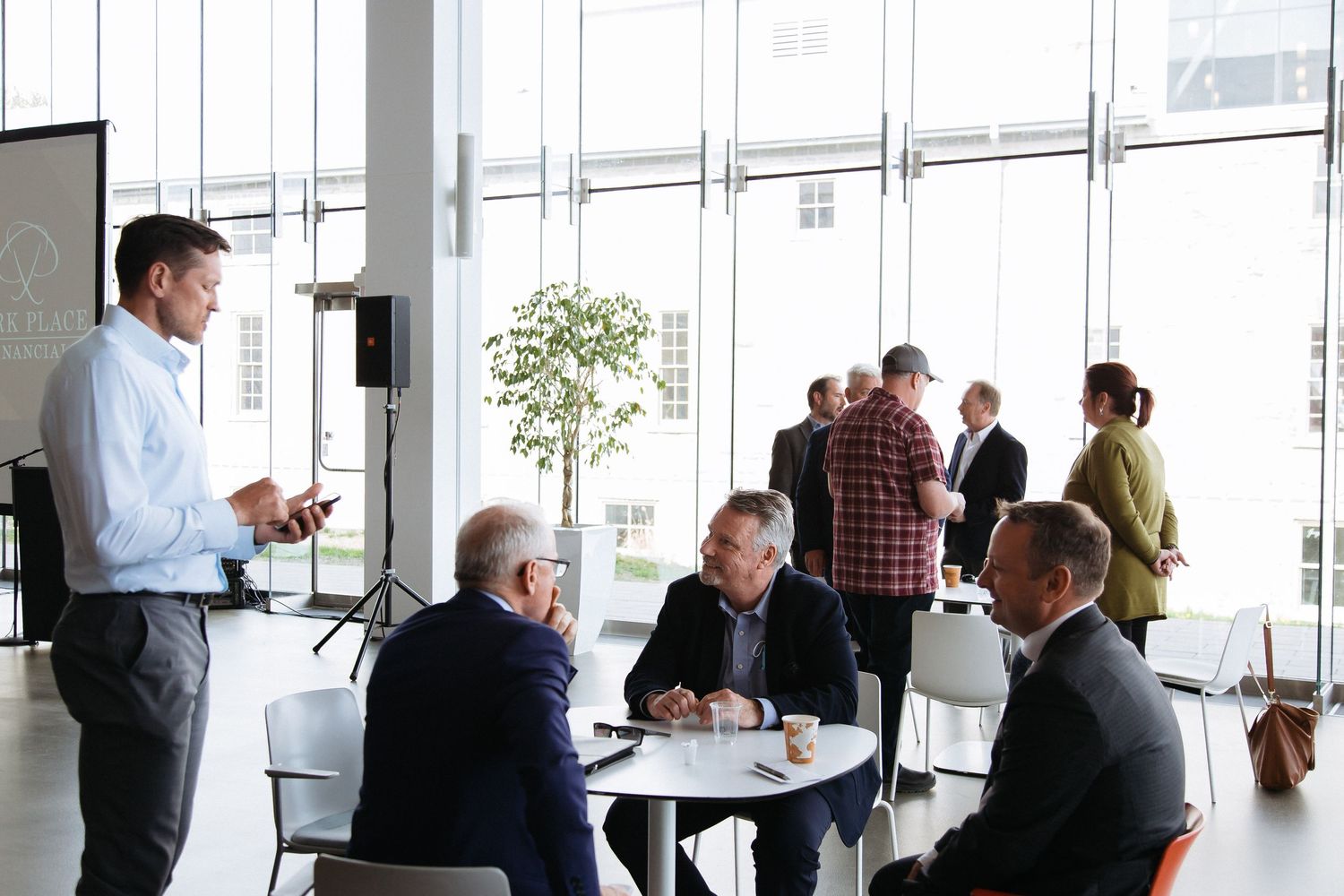 People having informal meetings in a bright office space with large windows.