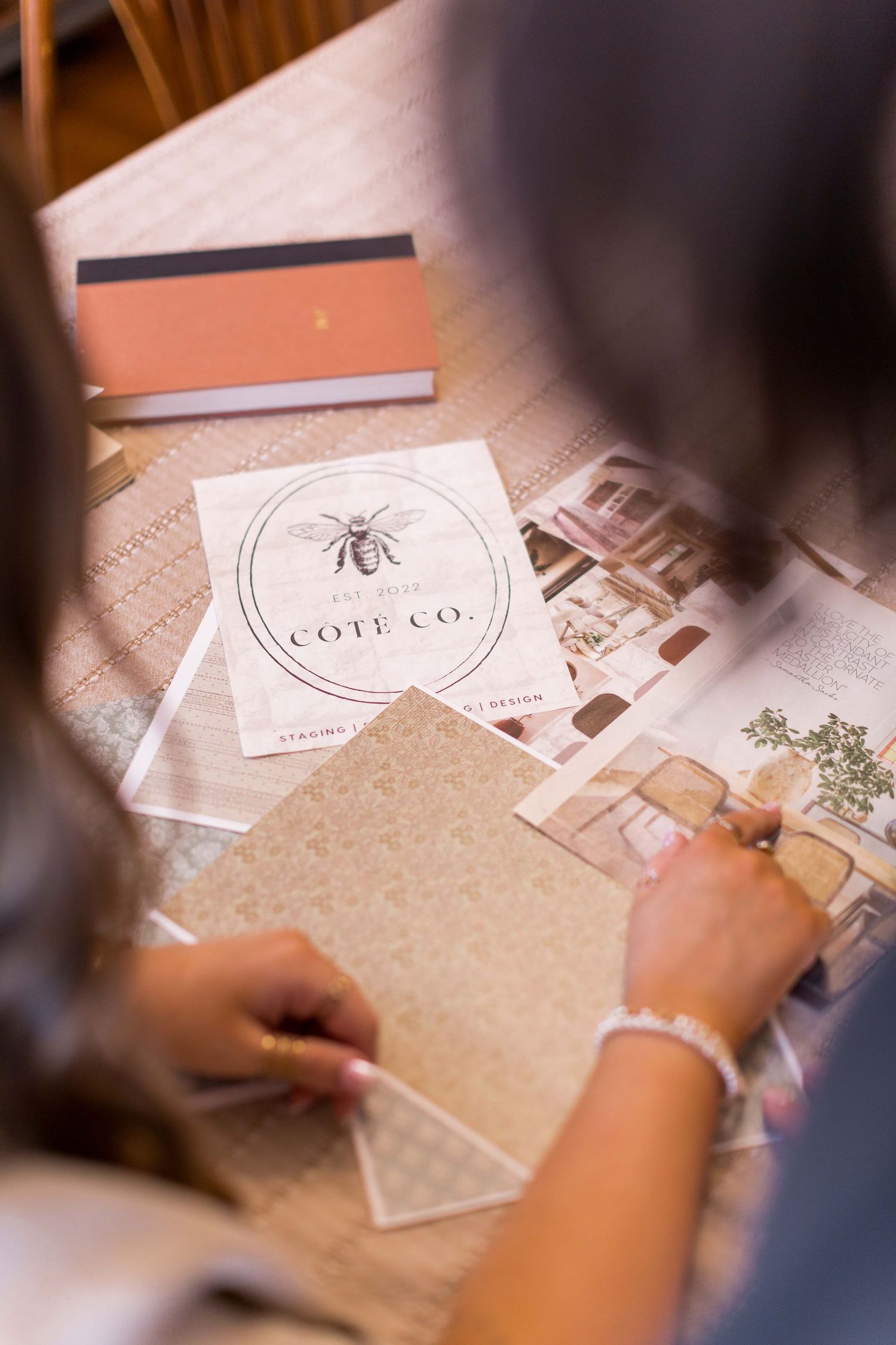 Close-up of business cards and branding materials being reviewed on wooden surface.