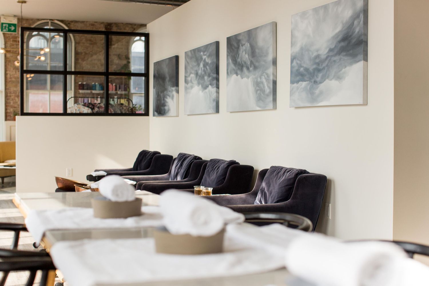 Contemporary living space with abstract gray artwork series displayed on white walls.