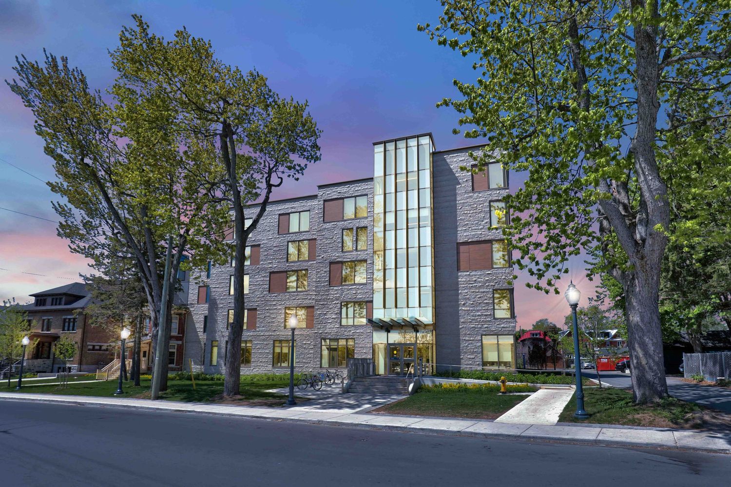 Multi-story residential building complex with glass and stone facade.