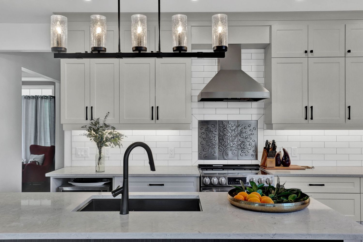 Contemporary white kitchen with subway tile backsplash and pendant lighting.