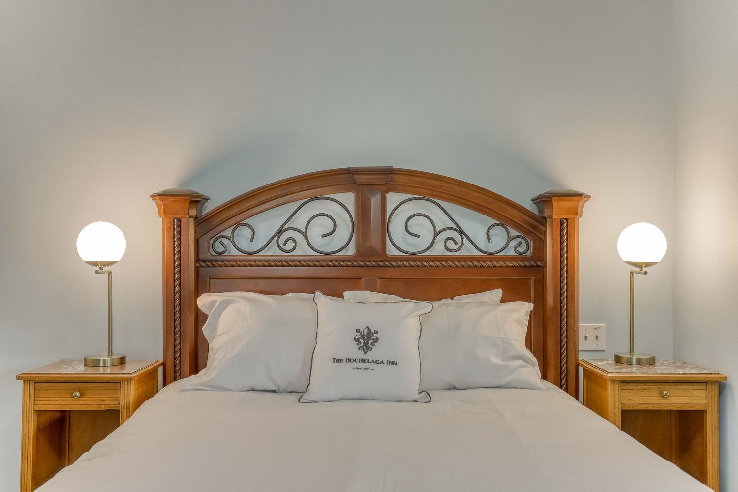 Luxurious hotel bedroom with wooden headboard and matching nightstands.