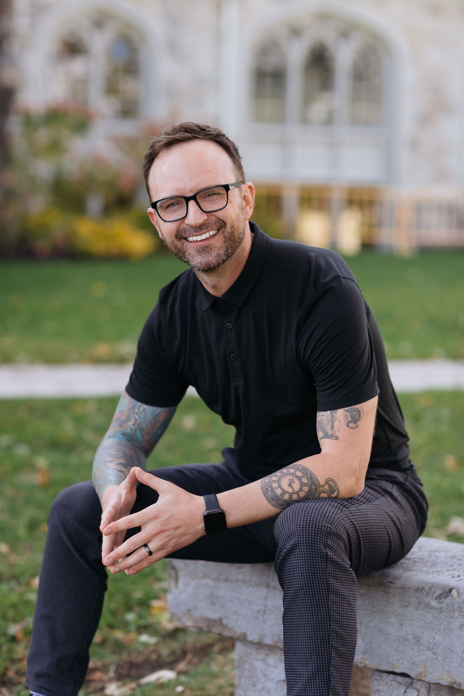 Man in black shirt and glasses sitting casually outdoors showing different relaxed poses.