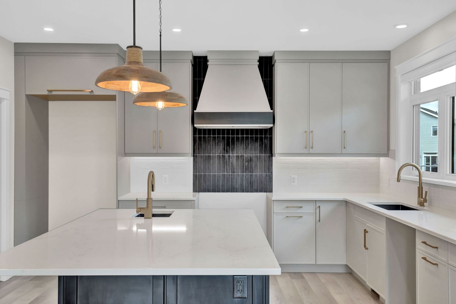 Modern white kitchen interior with pendant lights and minimalist design.