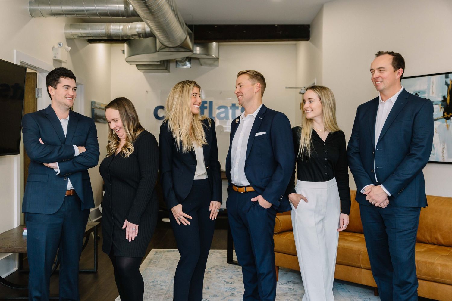Business team networking in a modern office space with exposed brick walls.