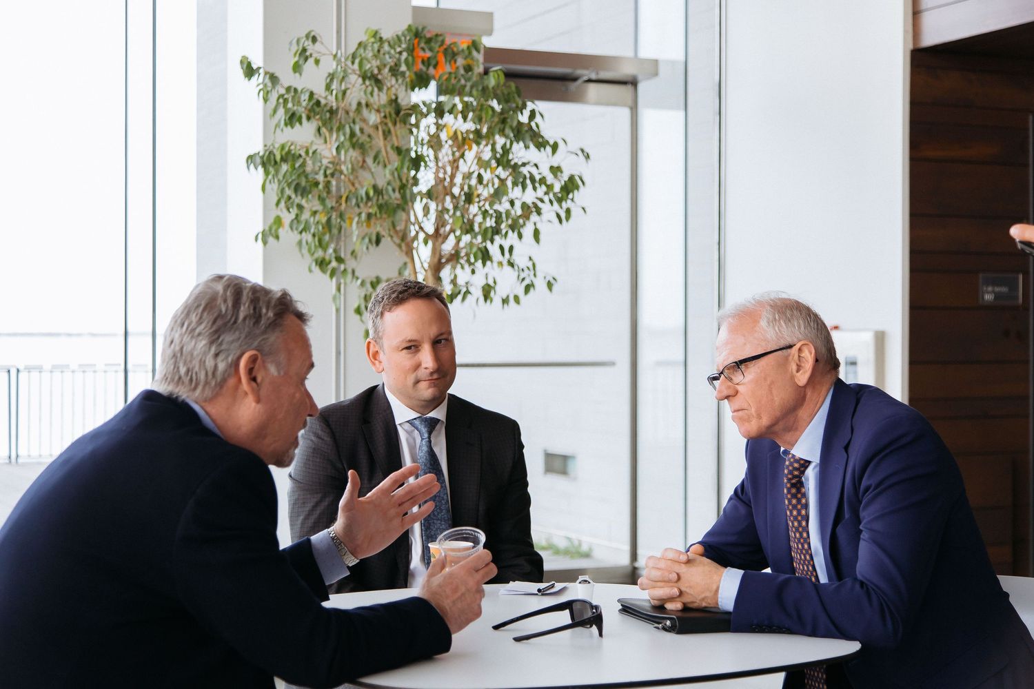 Group of professionals engaged in conversation at a modern office space.