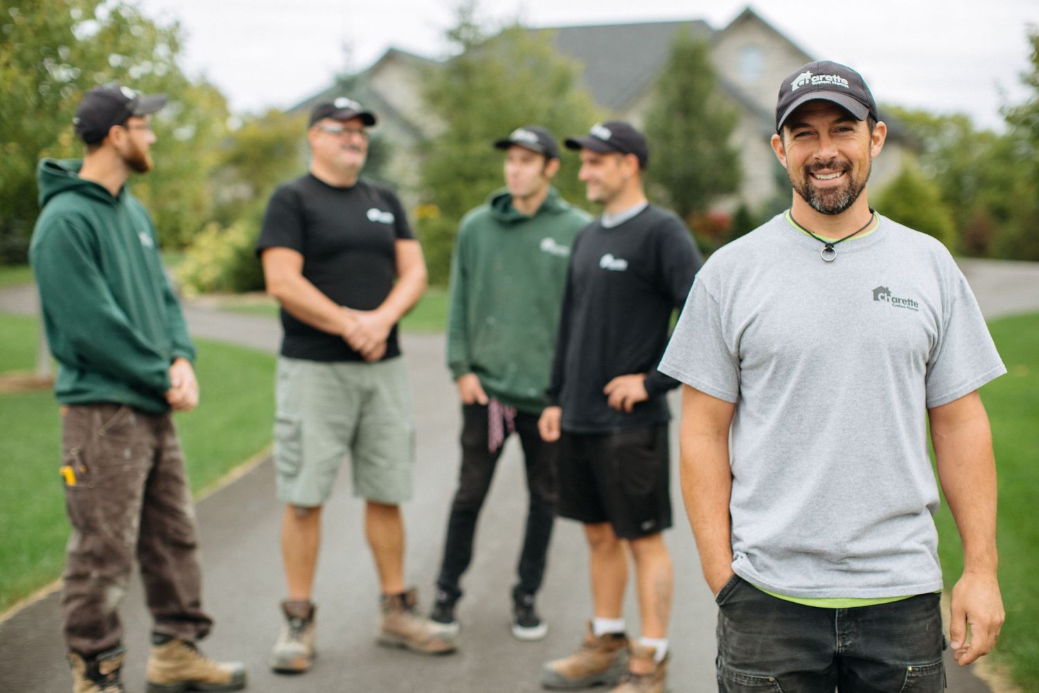 Outdoor group photo of landscaping or maintenance team in branded uniforms.