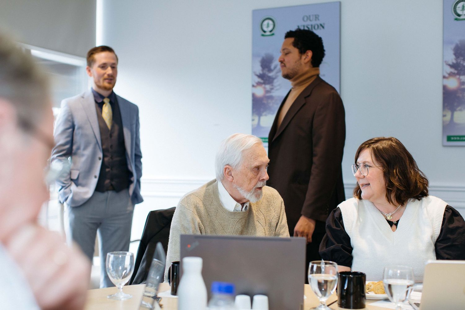 Professional meeting taking place in a bright conference room with white walls and office decor.