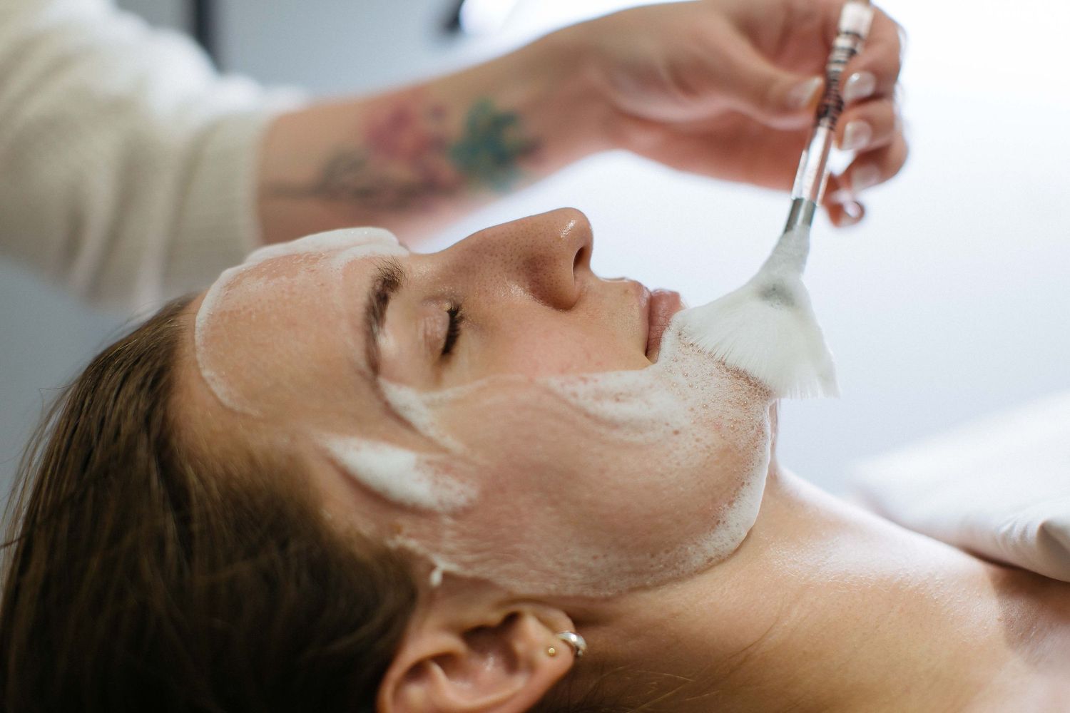 Close-up of spa facial treatment with white mask being applied.